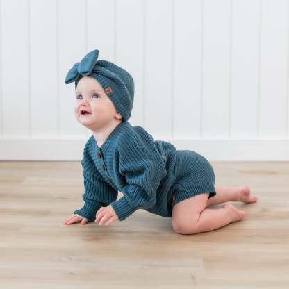 Toddler crawling wearing the Chunky Knit Romper in Atlantic and matching Chunky knit bow headband