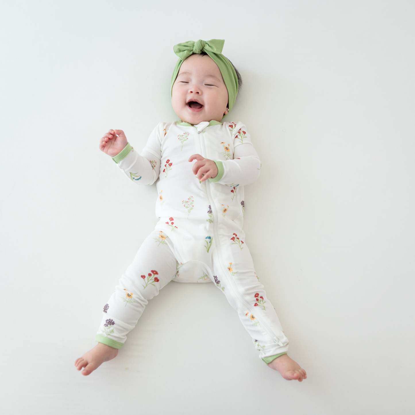 Baby in Zippered Romper in Wildflower and Honu Headband Bow