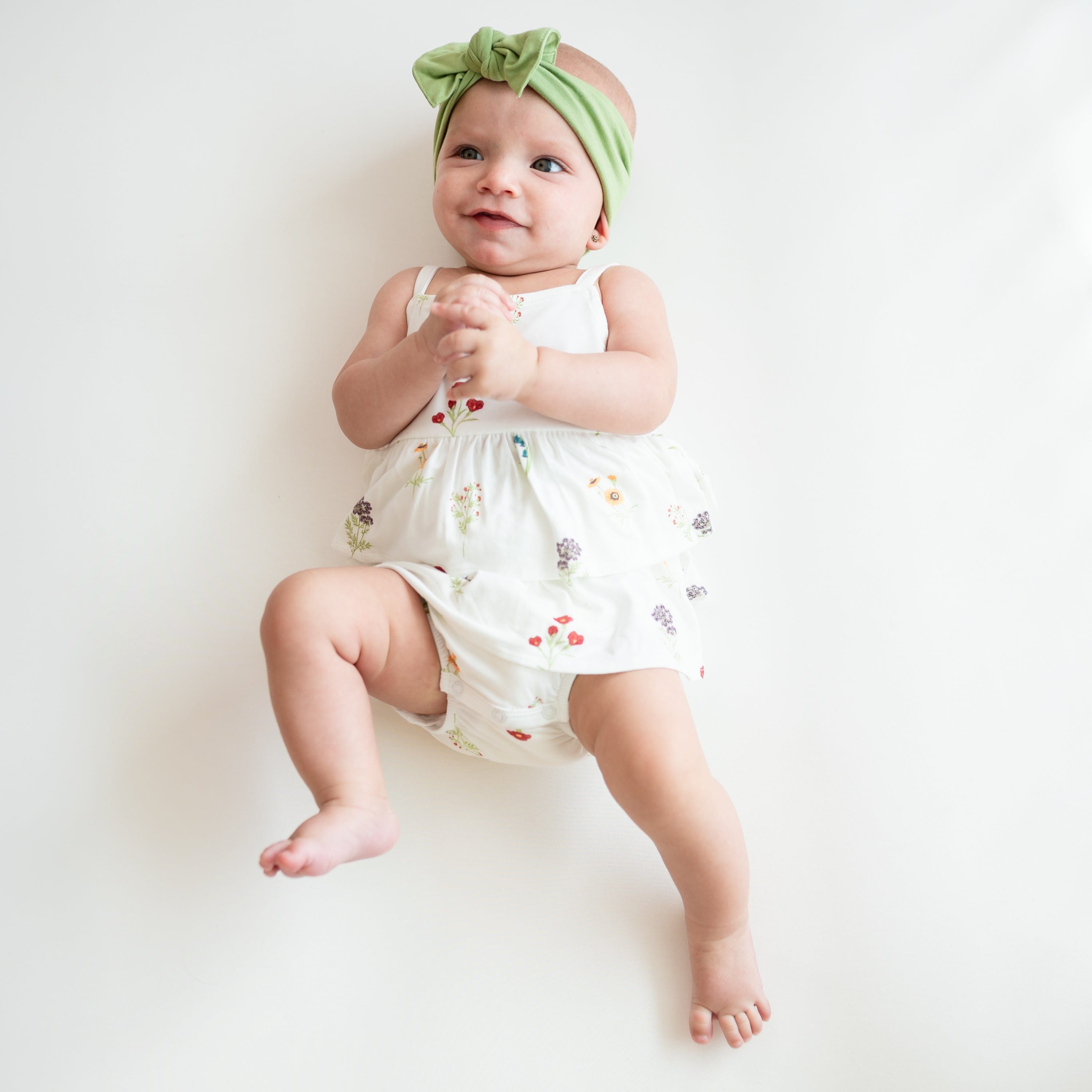 Baby wearing Spaghetti Strap Ruffle Romper in Wildflower and Honu Knotted Headband Bow