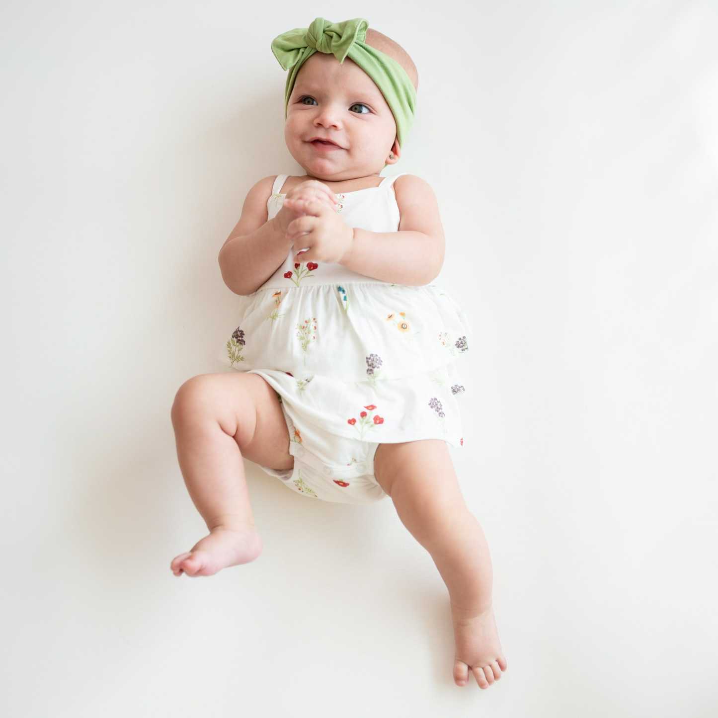 Baby wearing Spaghetti Strap Ruffle Romper in Wildflower and Honu Knotted Headband Bow