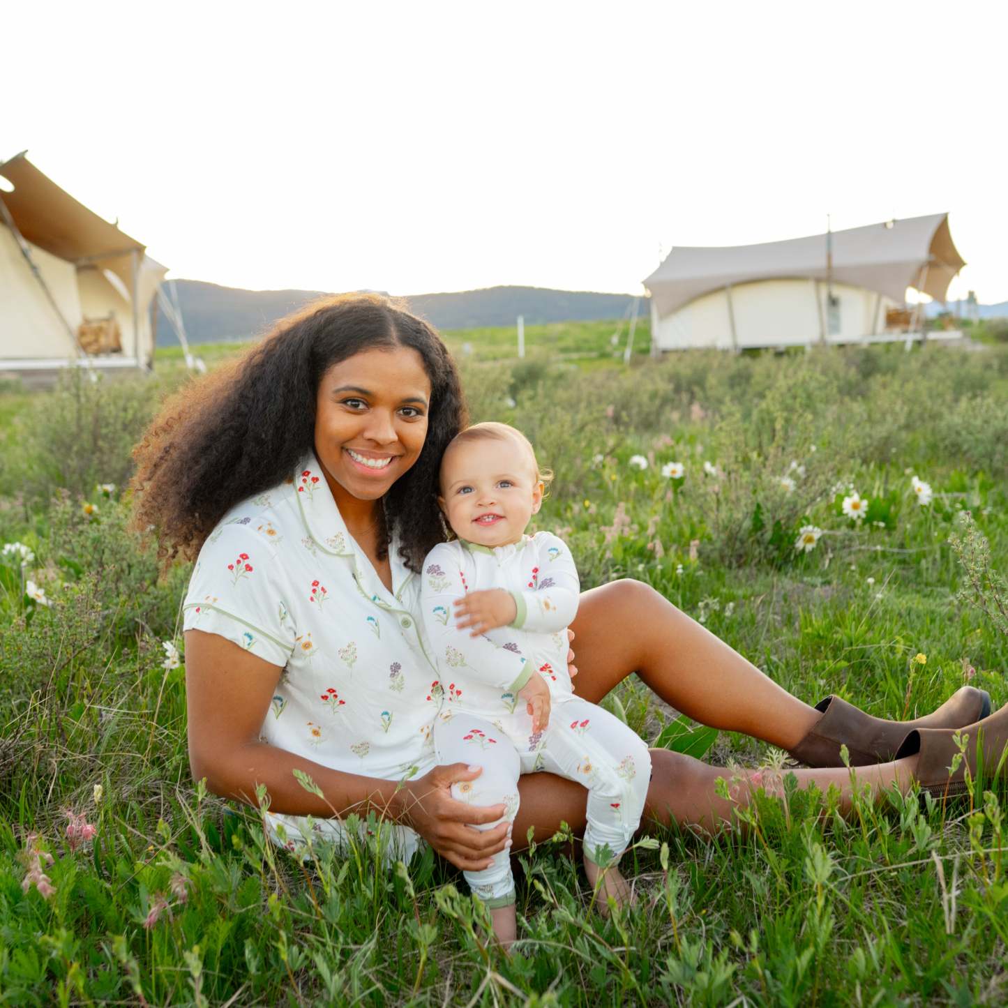 Mom wearing Short Sleeve Pajama Set in Wildflower cuddling toddler modeling Zippered Romper in Wildflower at Yellowstone National Park