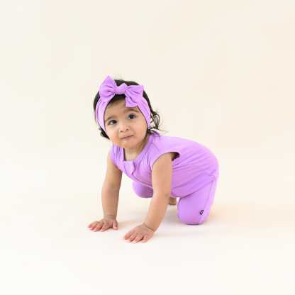 Toddler wearing Kyte Baby Sleeveless Zippered Romper in Poi purple