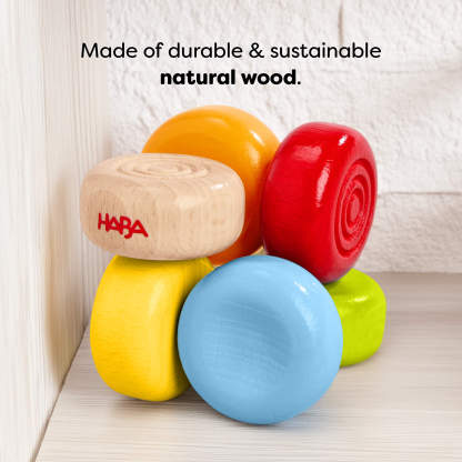 HABA Color Drops Wooden Grasping and Teething Toy on a light  wood shelf with text reading 'Made of durable and sustainable natural wood.'