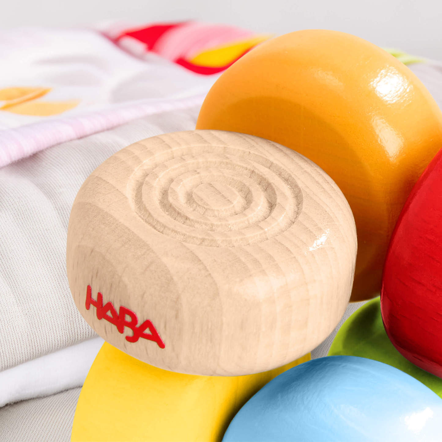 HABA Color Drops Wooden Grasping and Teething Toy on a soft fabric background.