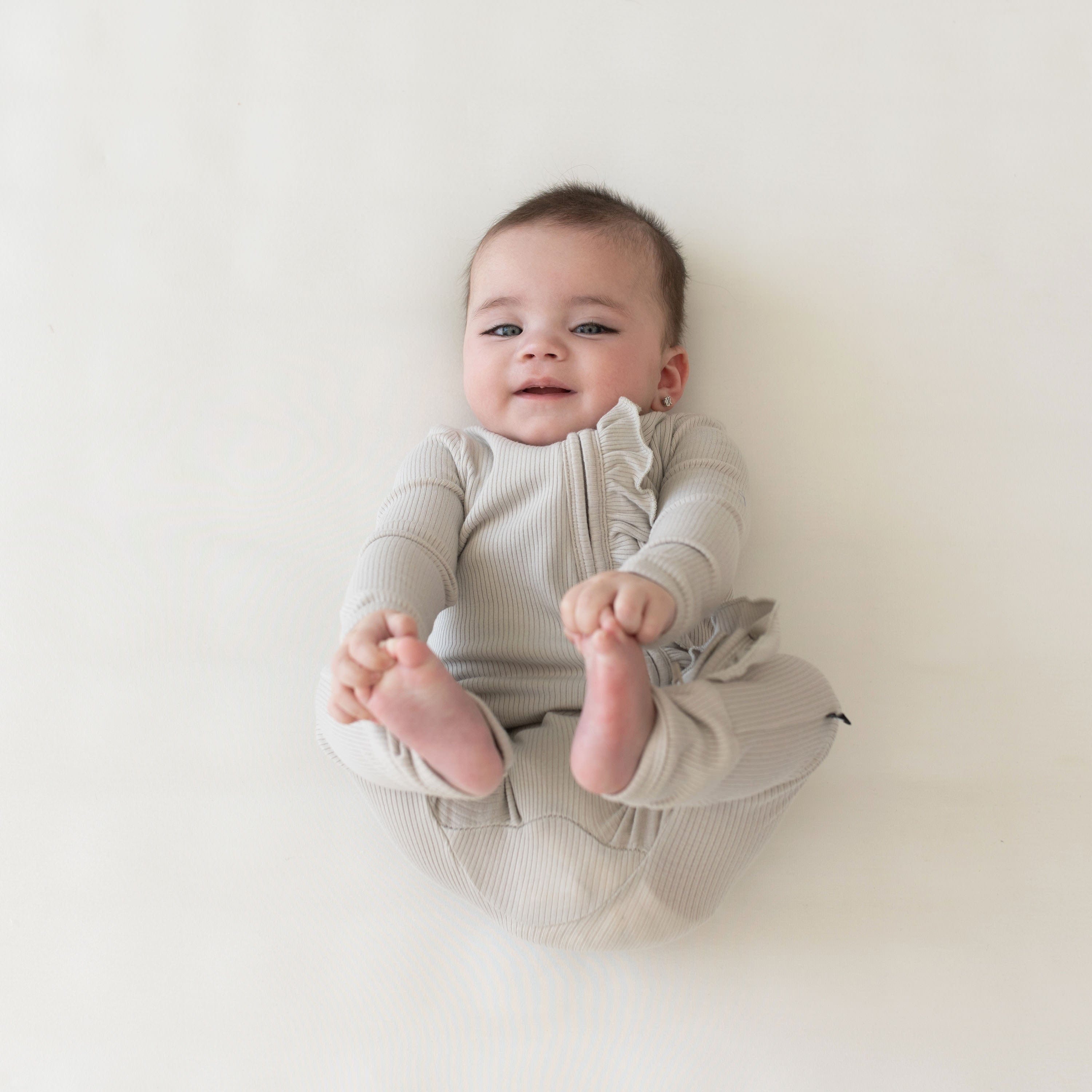 Kyte Baby Ribbed Ruffle Zipper Romper Ribbed Ruffle Zipper Romper in Oat