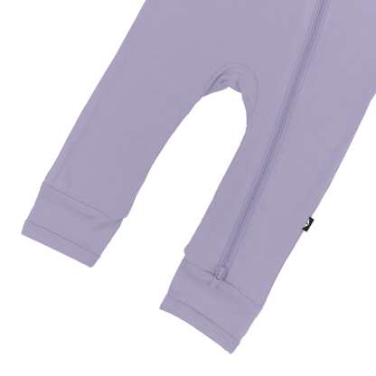 Close up of  open feet and bottom zipper on Kyte Baby Zippered Romper in Taro