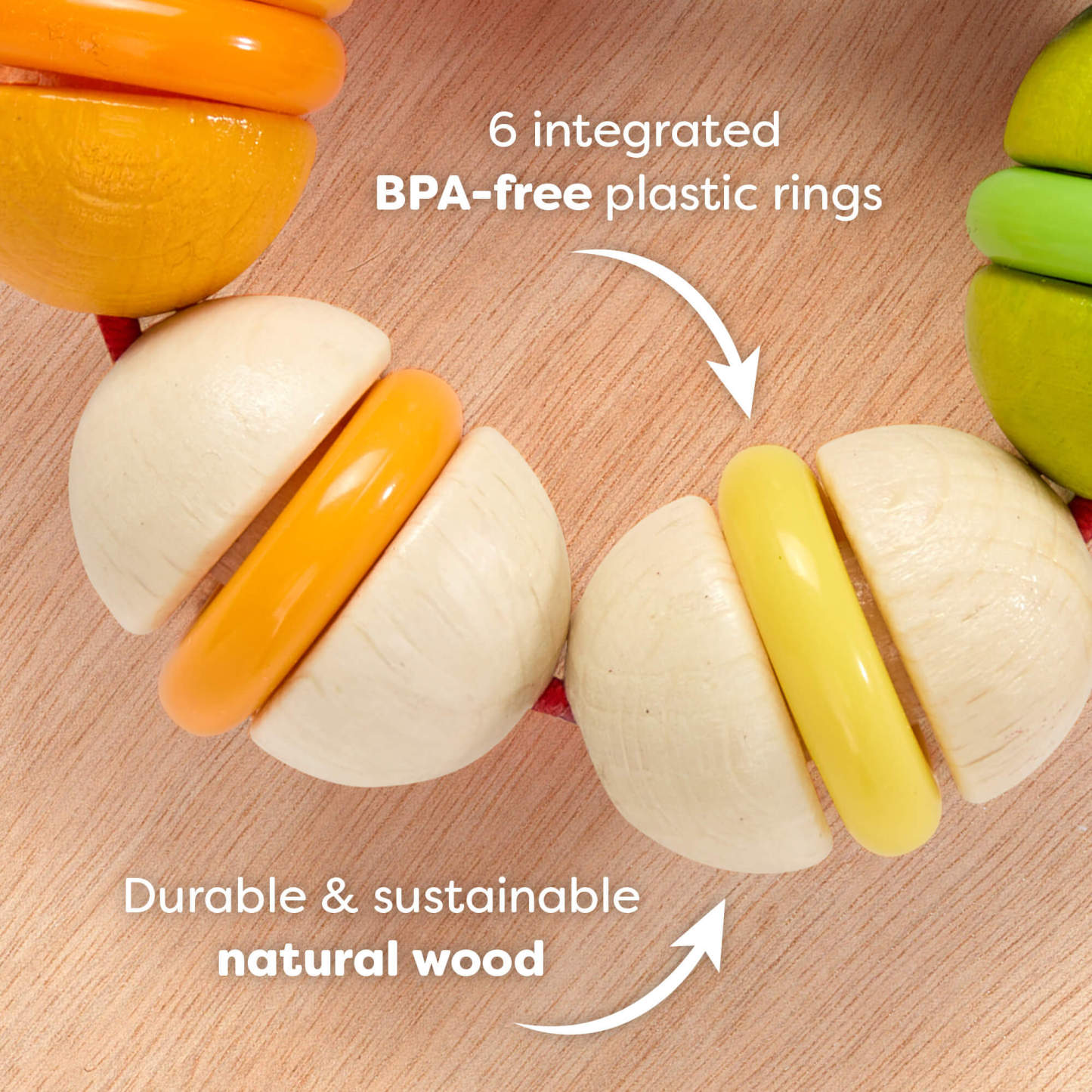 Rainbow Rattle Grasping and Teething Toy  on a wooden surface with text reading '6 integrated BPA-free plastic rings. Durable and sustainable natural wood'