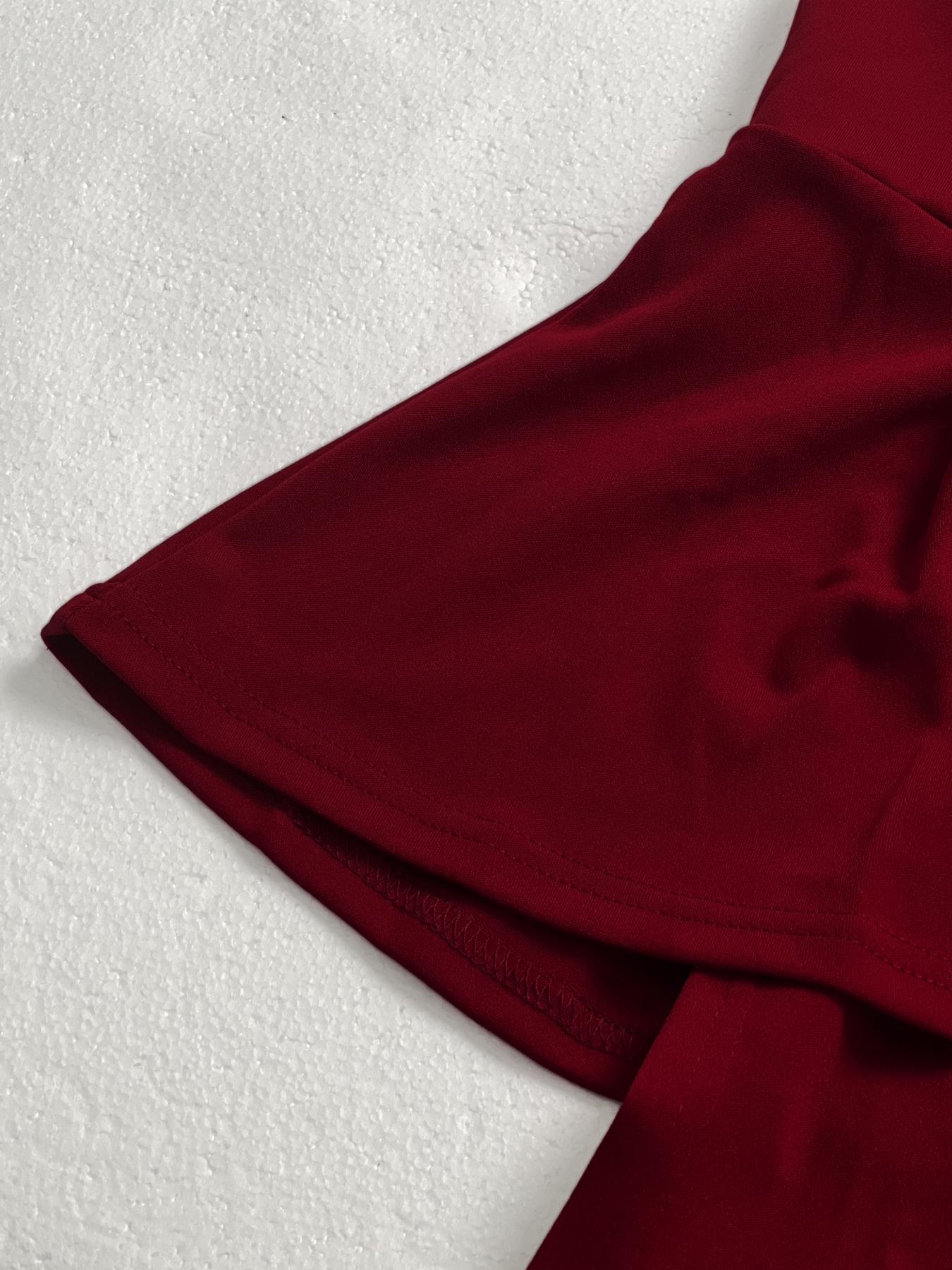 Woman's Red sleeveless two-piece suit with V-neck, frilly hem and wide legs.