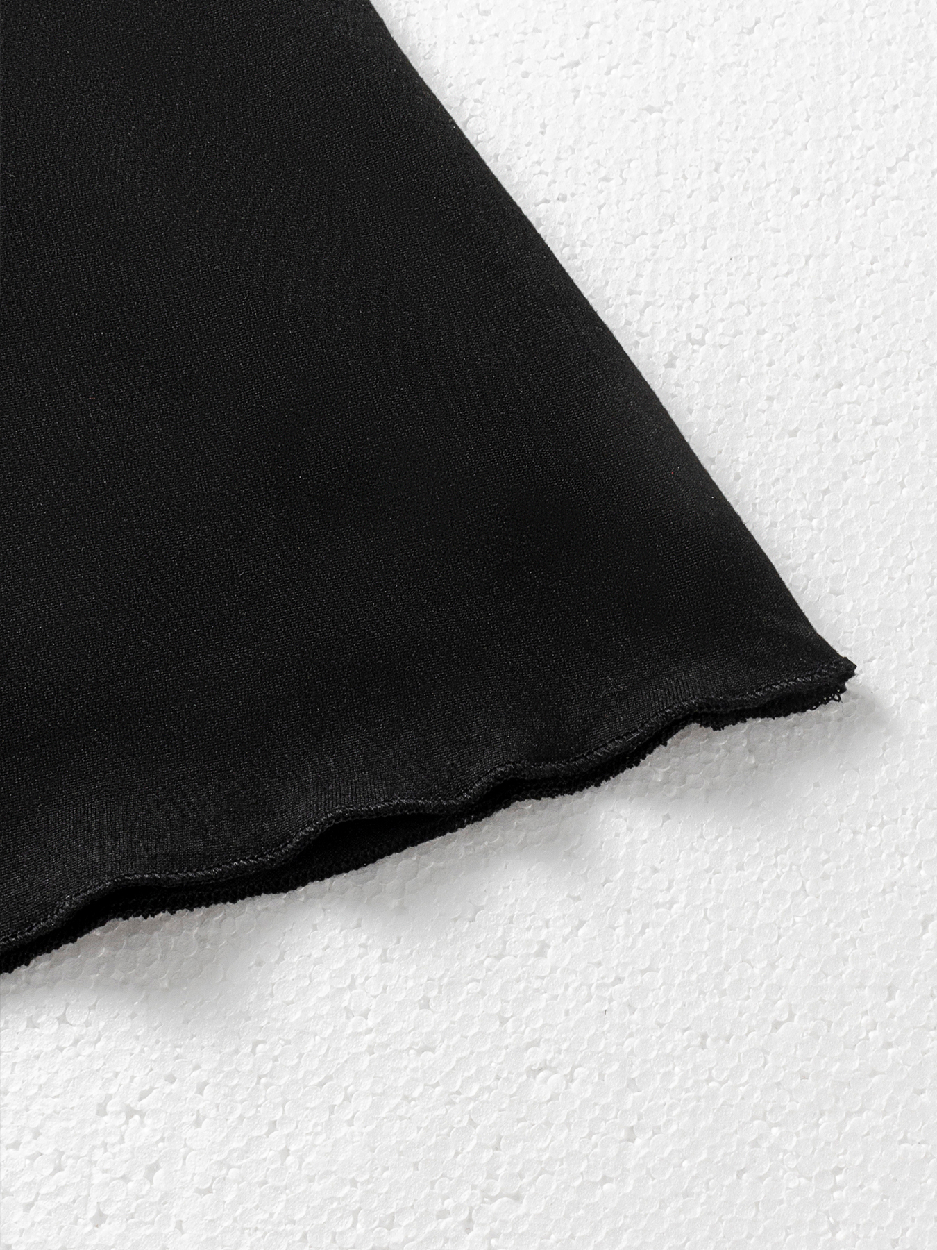 Woman's Black spaghetti strap mini dress with ruffled neckline and bow embellishment.