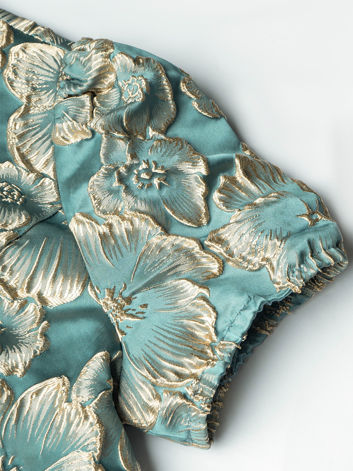 Women in flowered, bubble-sleeved, fish-tail dresses with waist-shrouding, hip-shrouding mid-skirts