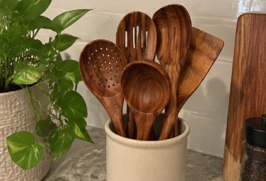 Wood utensils stored beside a houseplant