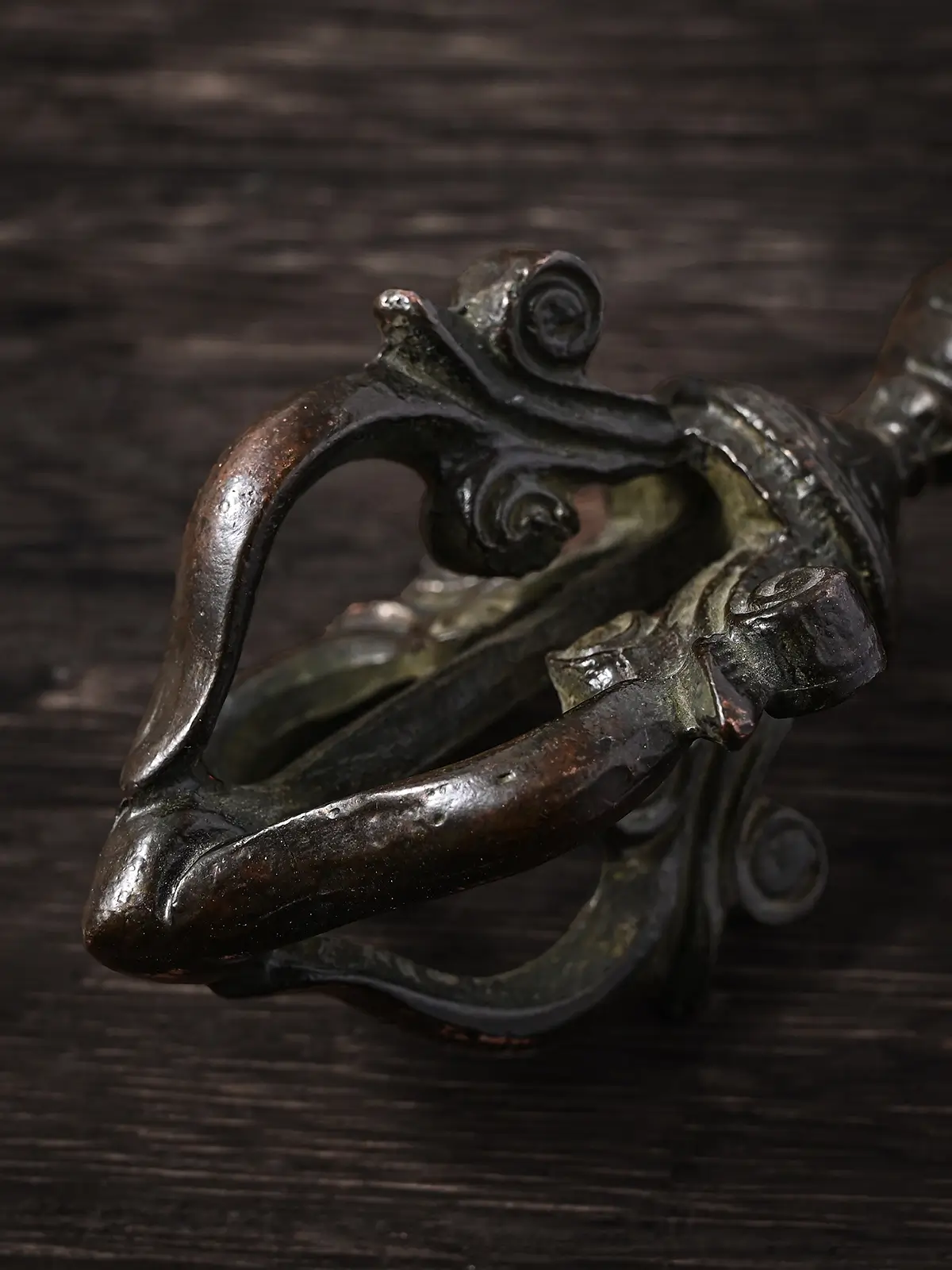 Close up of the curved prongs of an antique Tibetan vajra dorje, a traditional symbol used for energetic protection practice