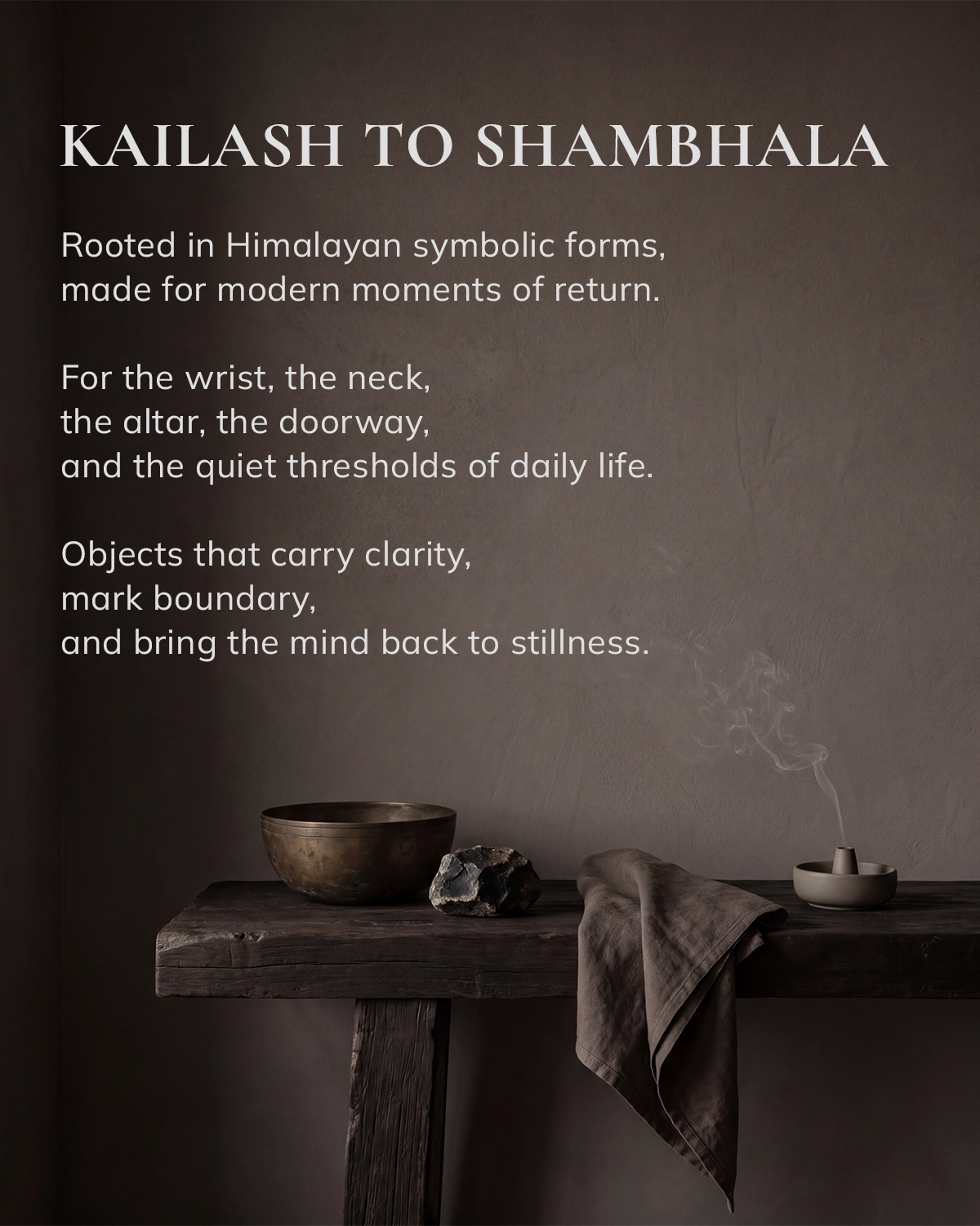 Brand image reading 'KAILASH TO SHAMBHALA' above a dark wooden table with a metal bowl, stone, folded cloth, and a smoking incense holder.