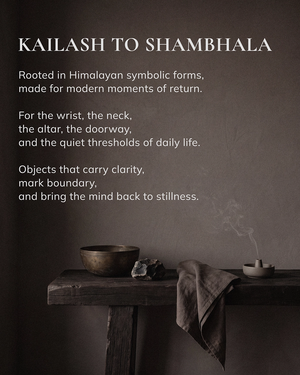 Brand image reading 'KAILASH TO SHAMBHALA' above a dark wooden table with a metal bowl, stone, folded cloth, and a smoking incense holder.