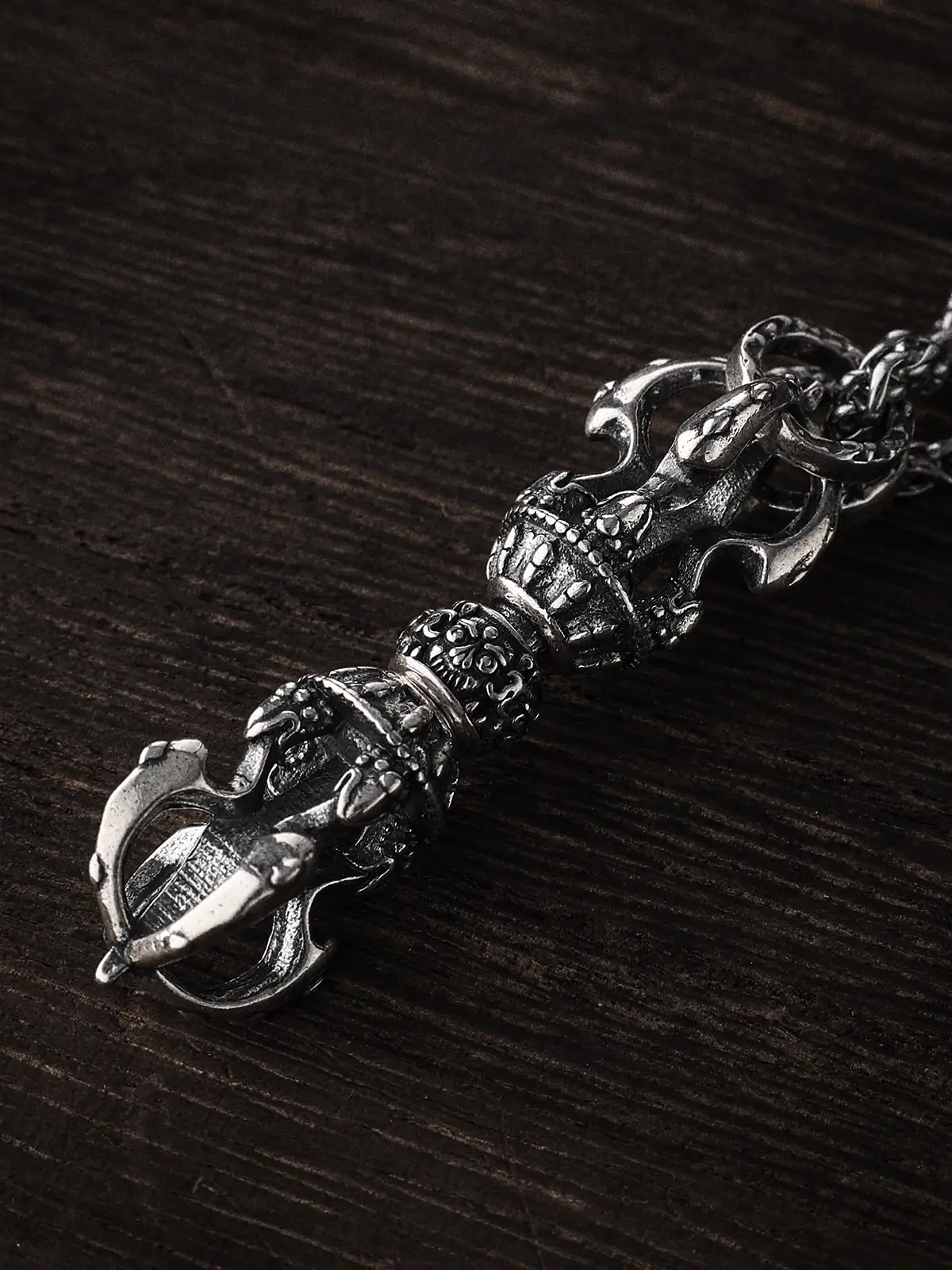 Macro shot of a Copper Vajra Pendant with heavy oxidized silver plating. Detail showing the rotating center sphere and hand-carved textures. High-quality Buddhist artifact reproduction.