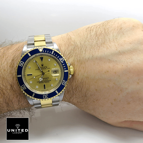rolthtex Submariner 16613 Yellow Gold Dial Blue Bezel Replica on his arm