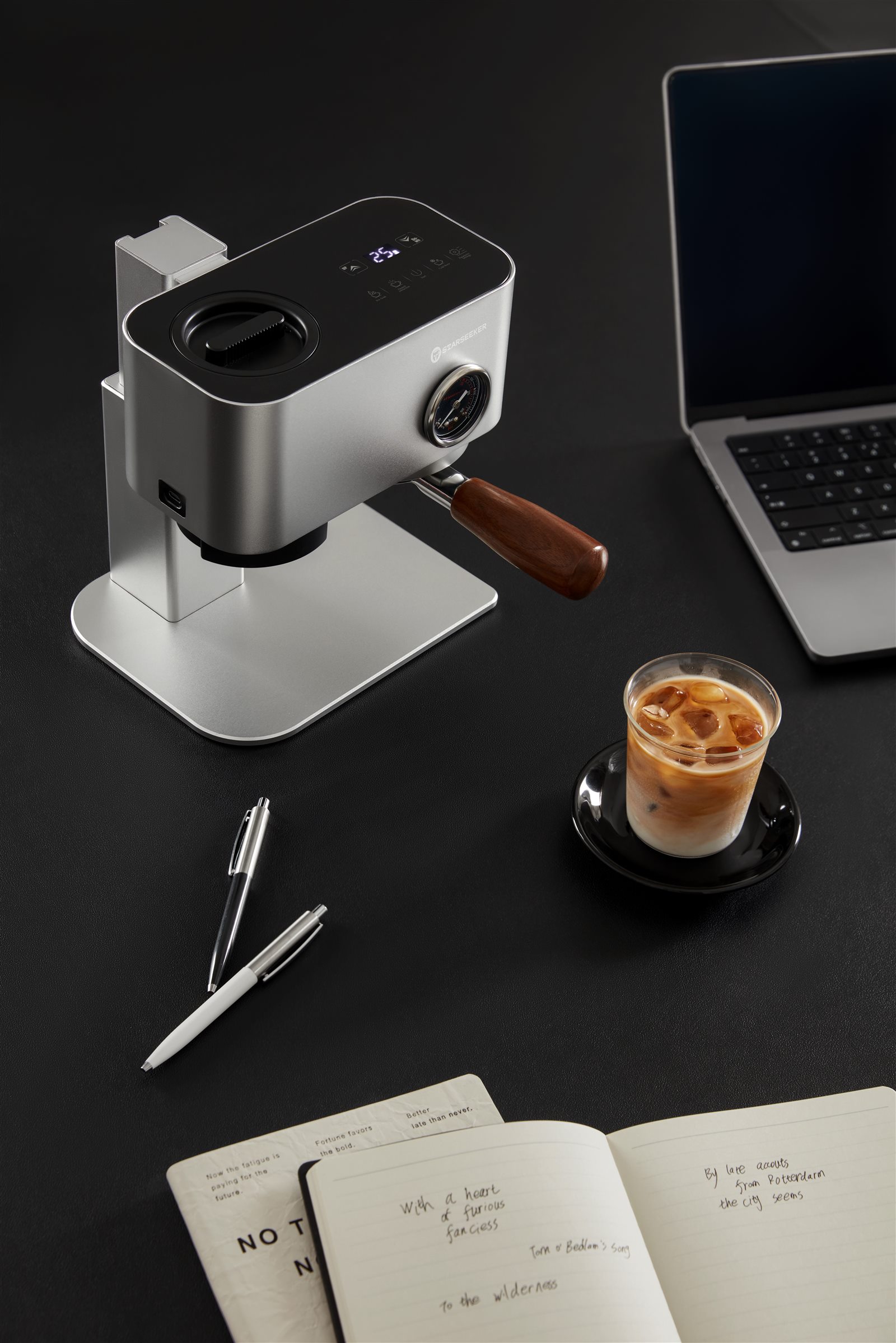 Compact Omni58X espresso machine beside a laptop and iced coffee