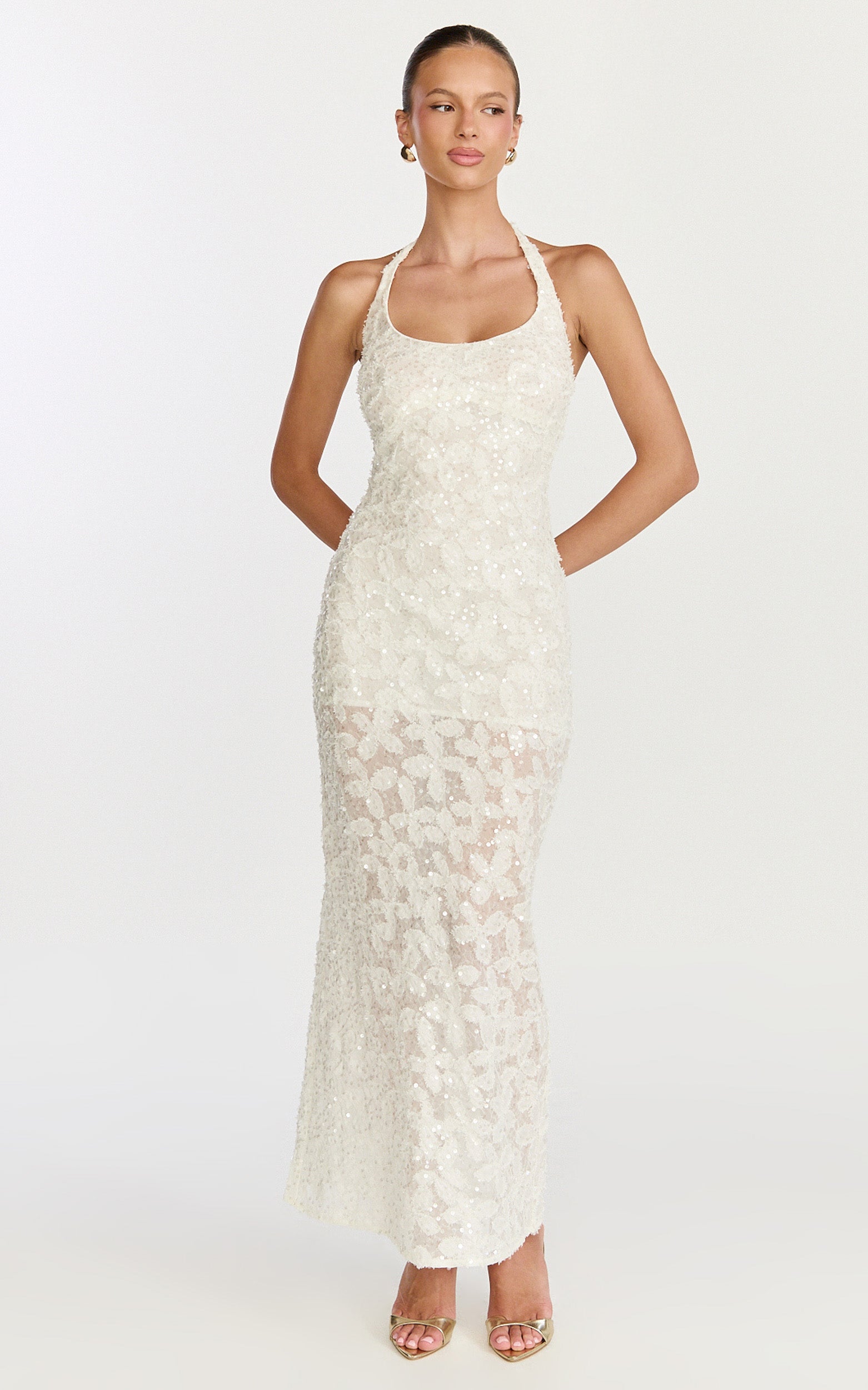 Model is wearing a halter neck backless body-con maxi dress in off white.