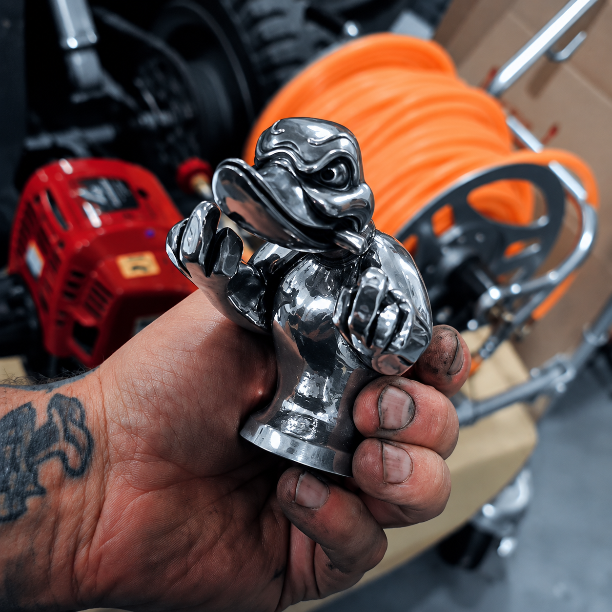 Polished rebellious duck ornament held in a workshop