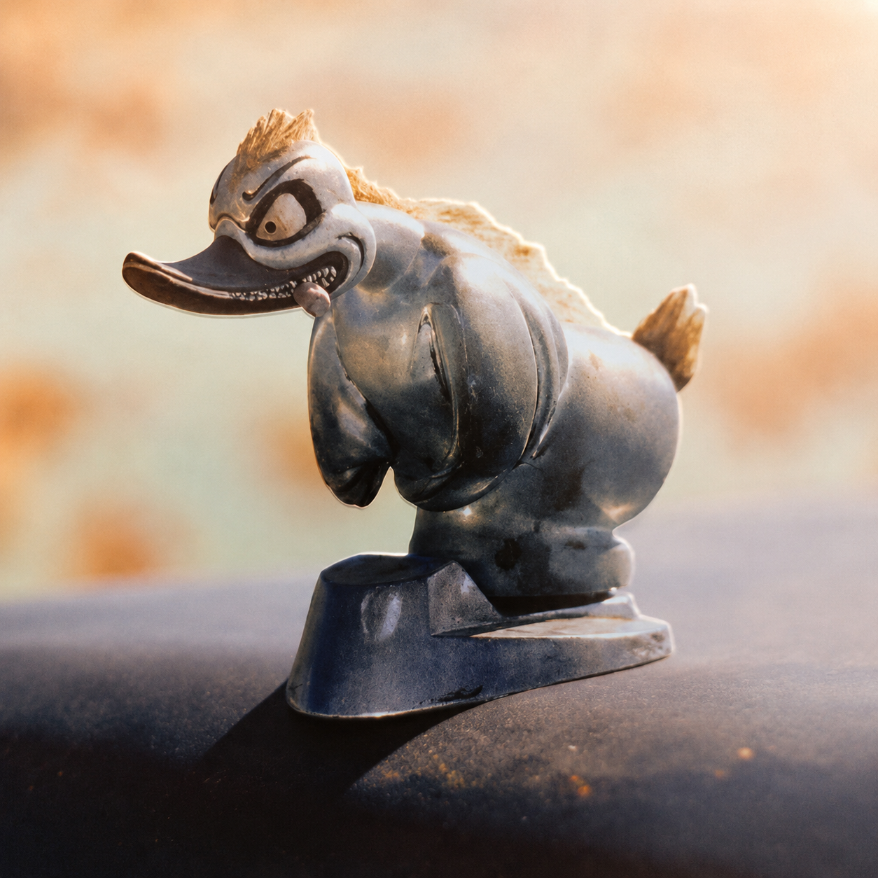 Convoy inspired angry duck hood ornament mounted in a warm sunset setting