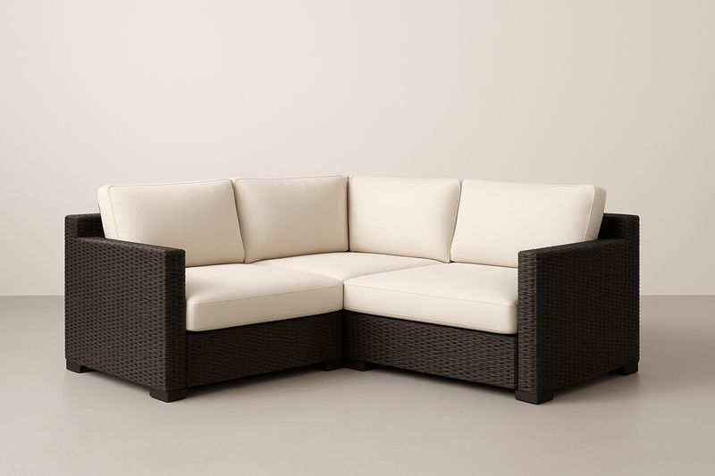 Divano angolare modulare in rattan con cuscini crema