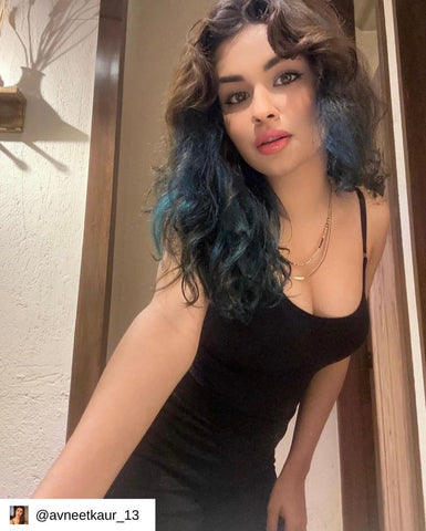 Woman wearing a black snatched bodysuit bodyshaper posing indoors.