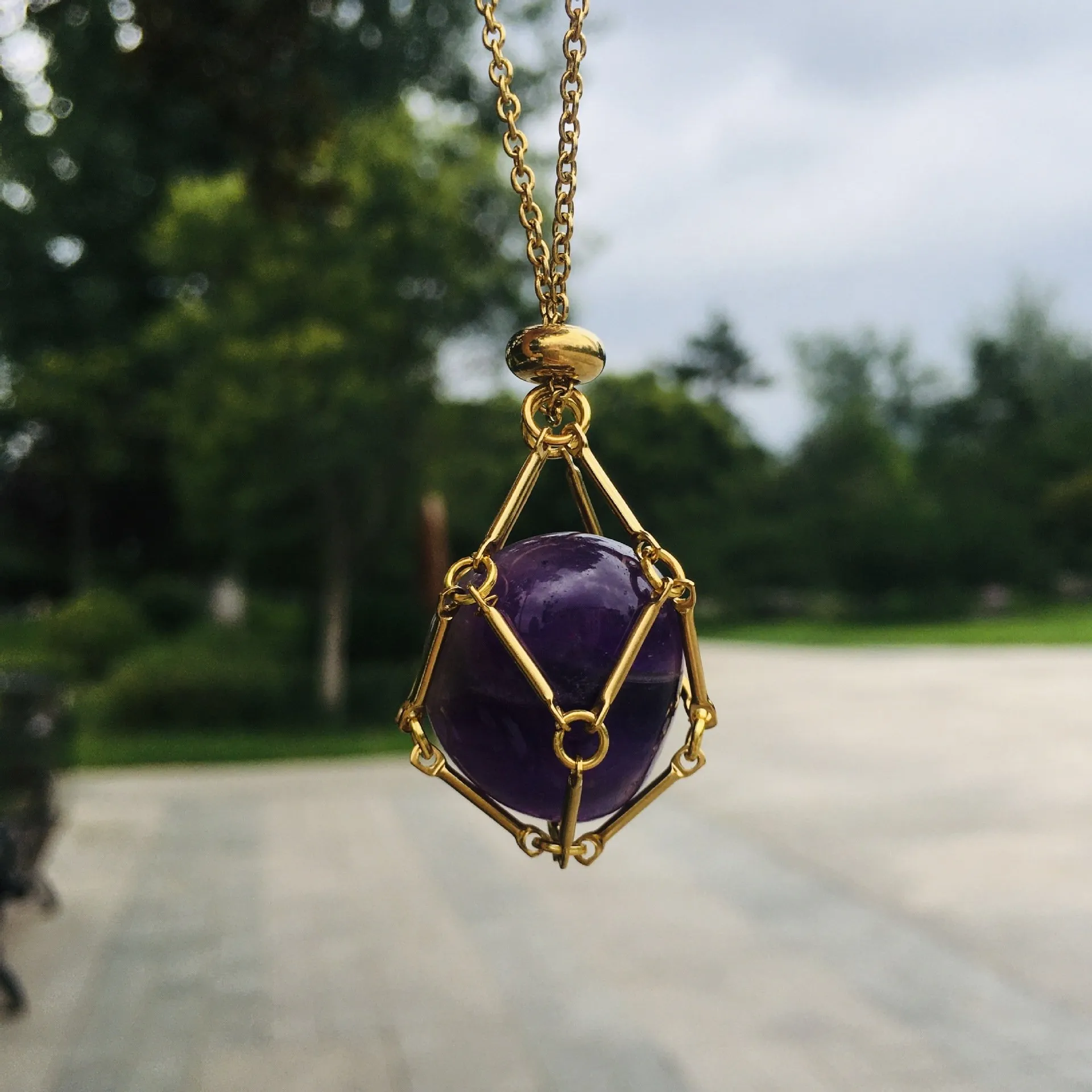 Gold crystal holder necklace with purple stone