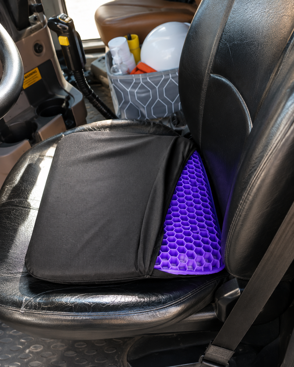 Black-covered purple silicone gel seat cushion used on a truck driver seat