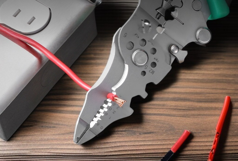 Electrician using multi functional wire stripping pliers