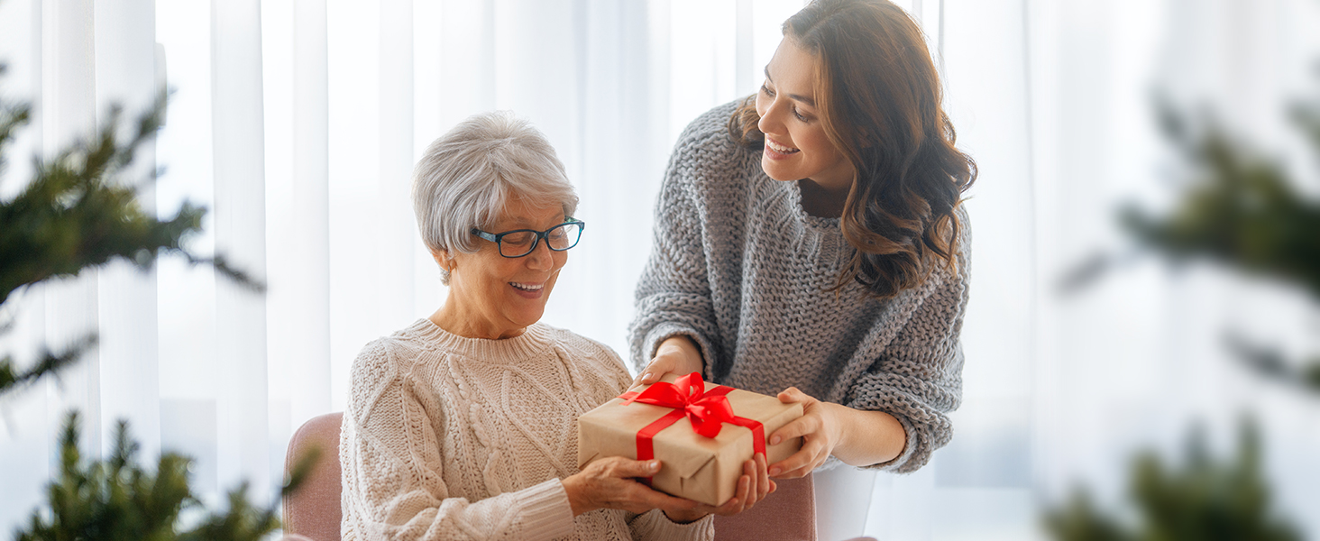 a woman presents a gift to an elderly woman