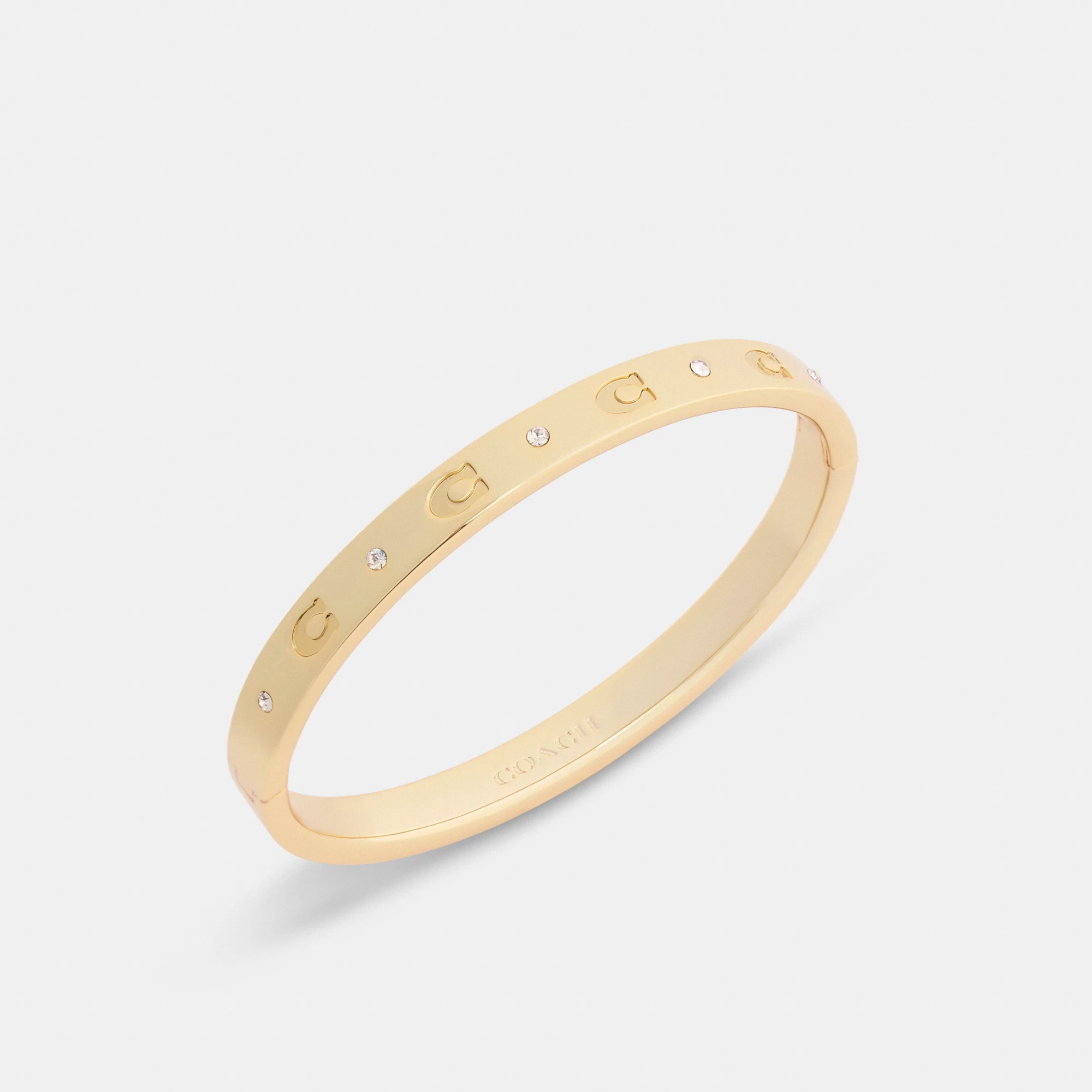 COACH®,Repeated C Hinged Bangle,Cubic Zirconia,Glass,Gem Embellishment,Logo,Stackable,Brass Gold,Casual,Clear,Inside View,Top View