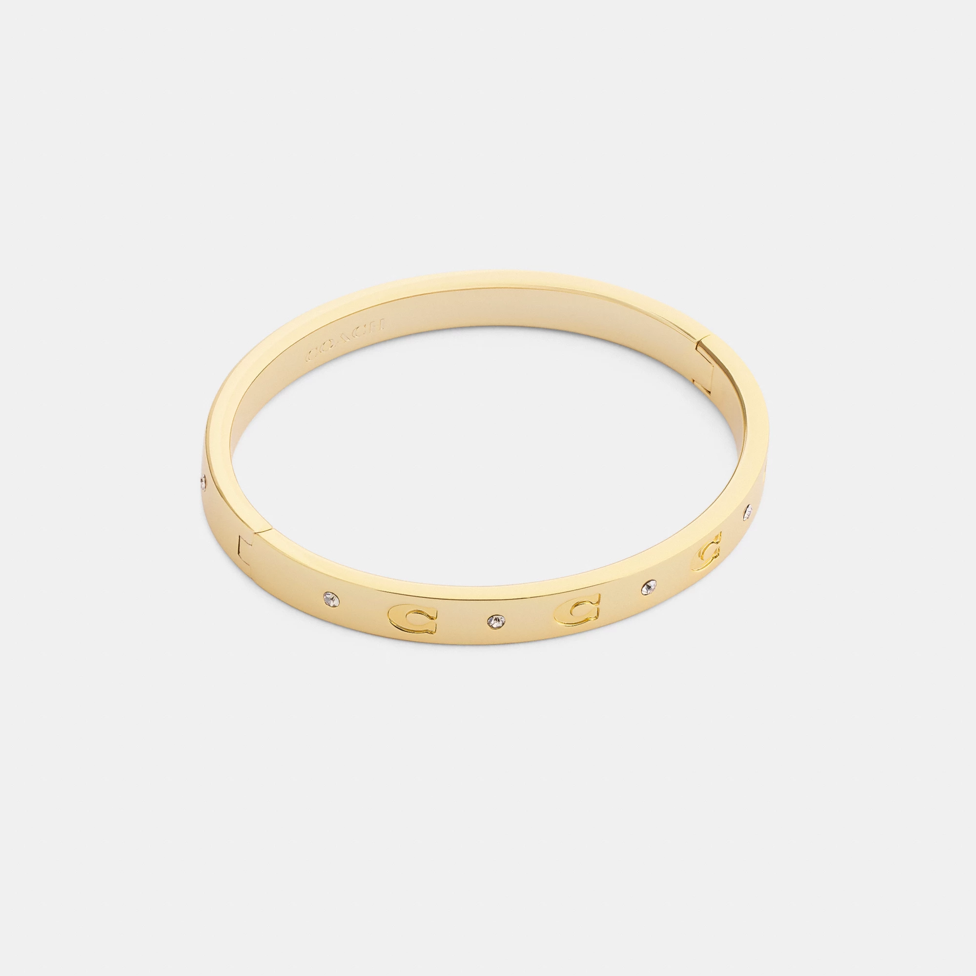 COACH®,Repeated C Hinged Bangle,Cubic Zirconia,Glass,Gem Embellishment,Logo,Stackable,Brass Gold,Casual,Clear,Front View