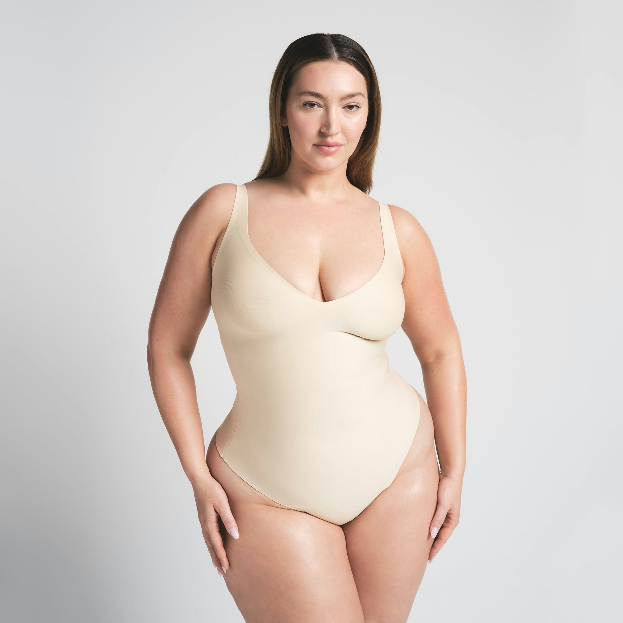 SKIMS BODY UNLINED PLUNGE THONG BODYSUIT - SAND