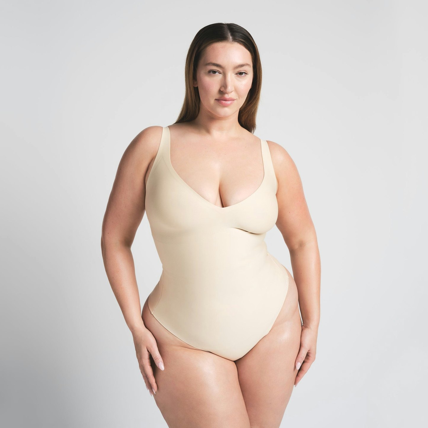 SKIMS BODY UNLINED PLUNGE THONG BODYSUIT - SAND
