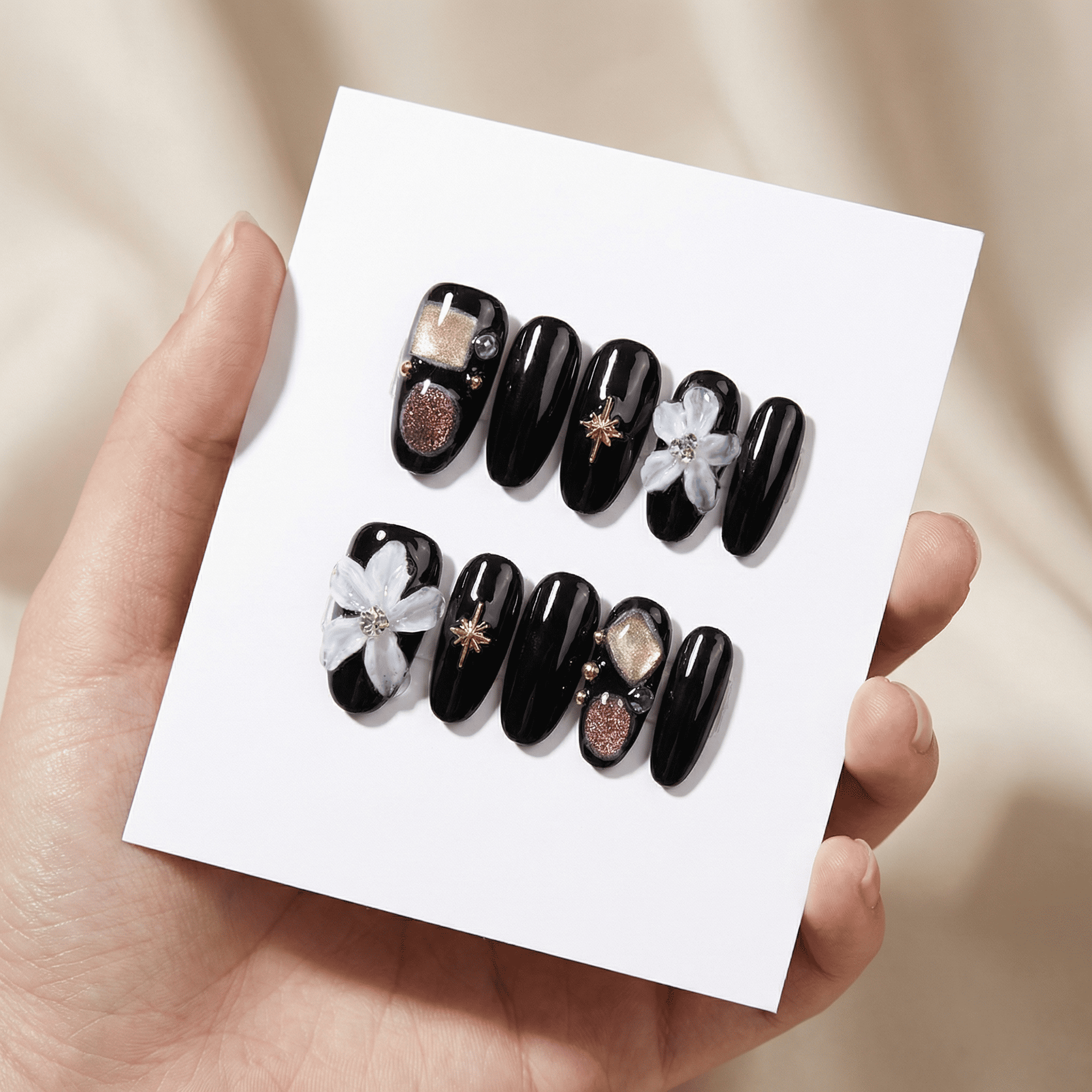 Glossy black press-on nails set with silver bow, checkerboard accent, and star details on a display card (S/M).