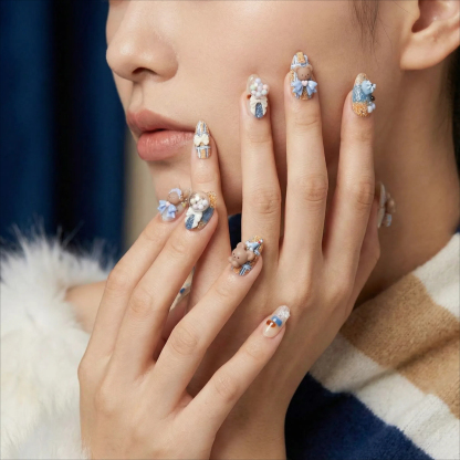 alt="Close up of blue and nude 3D teddy bear and bunny press on nails on model's hands"