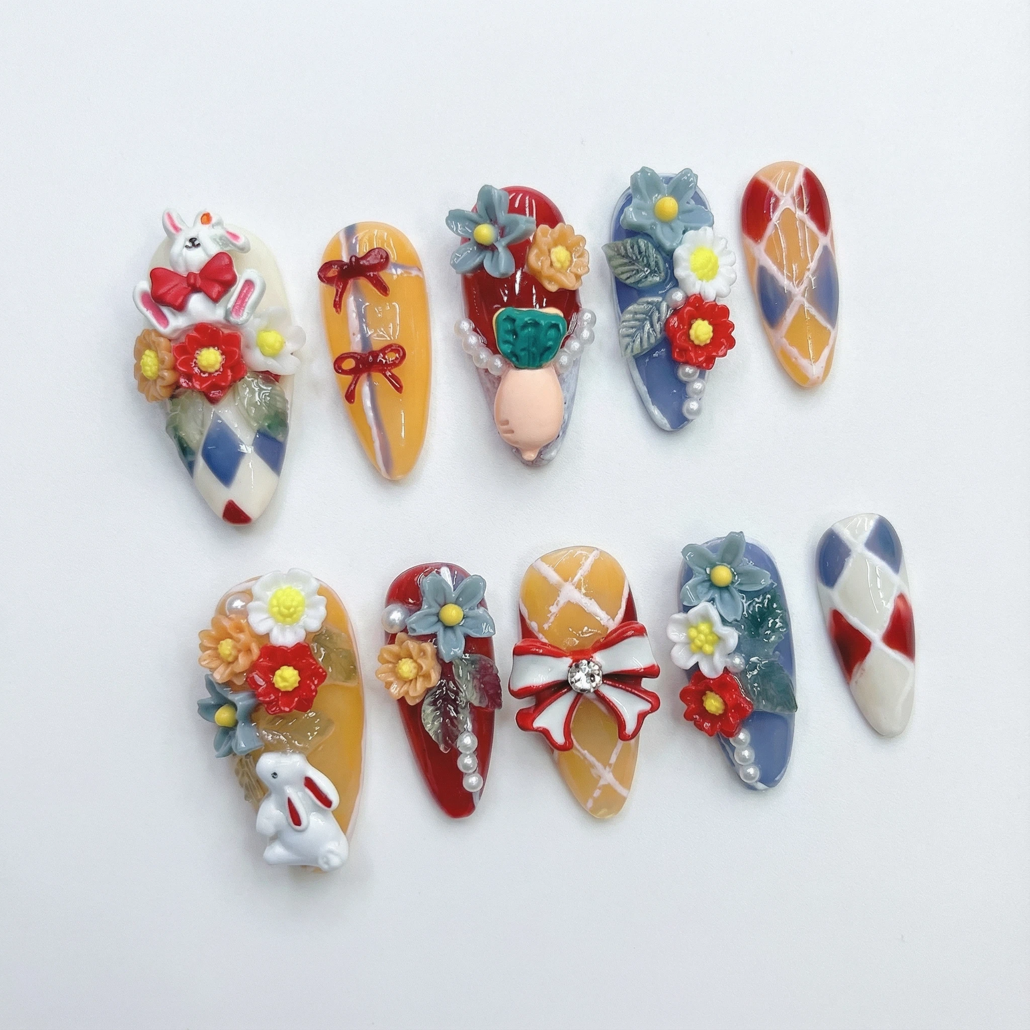 Colorful press-on nails flat lay, harlequin pattern with 3D flower statement tips