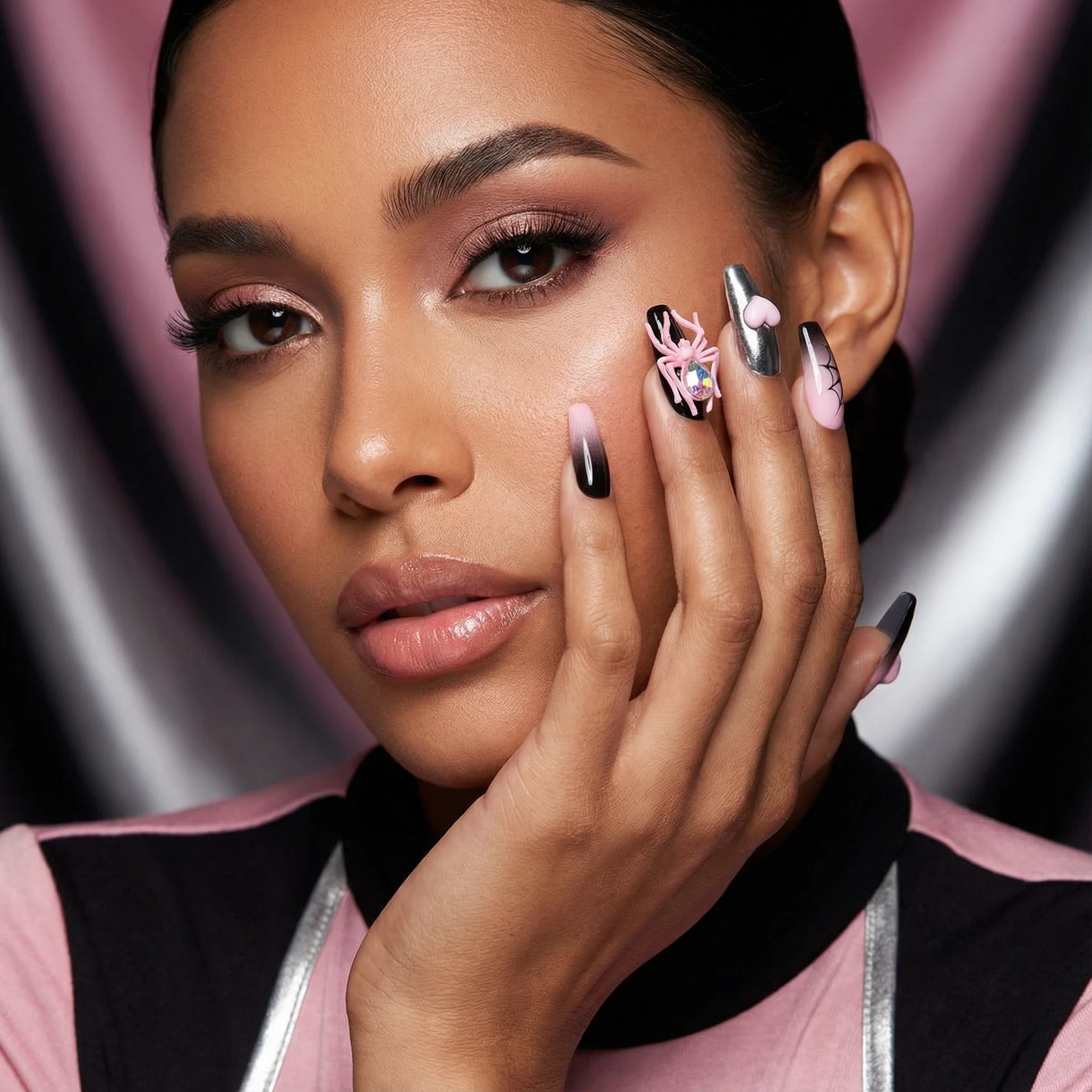 alt="Model showing long coffin pink and black ombre press on nails with 3D spider and heart details"