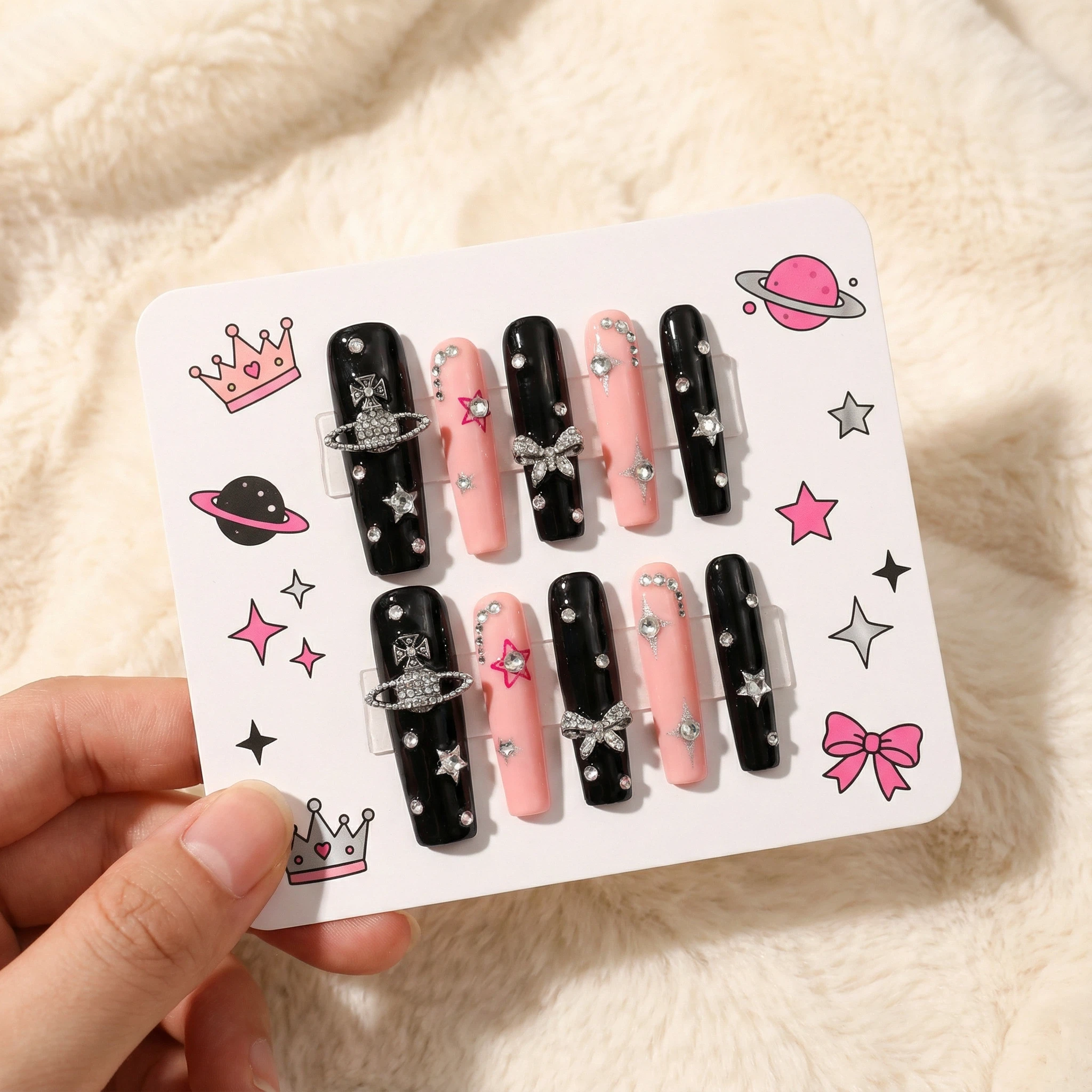 Black and pink gothic press-on nails on display card with cross details and silver rhinestone accents