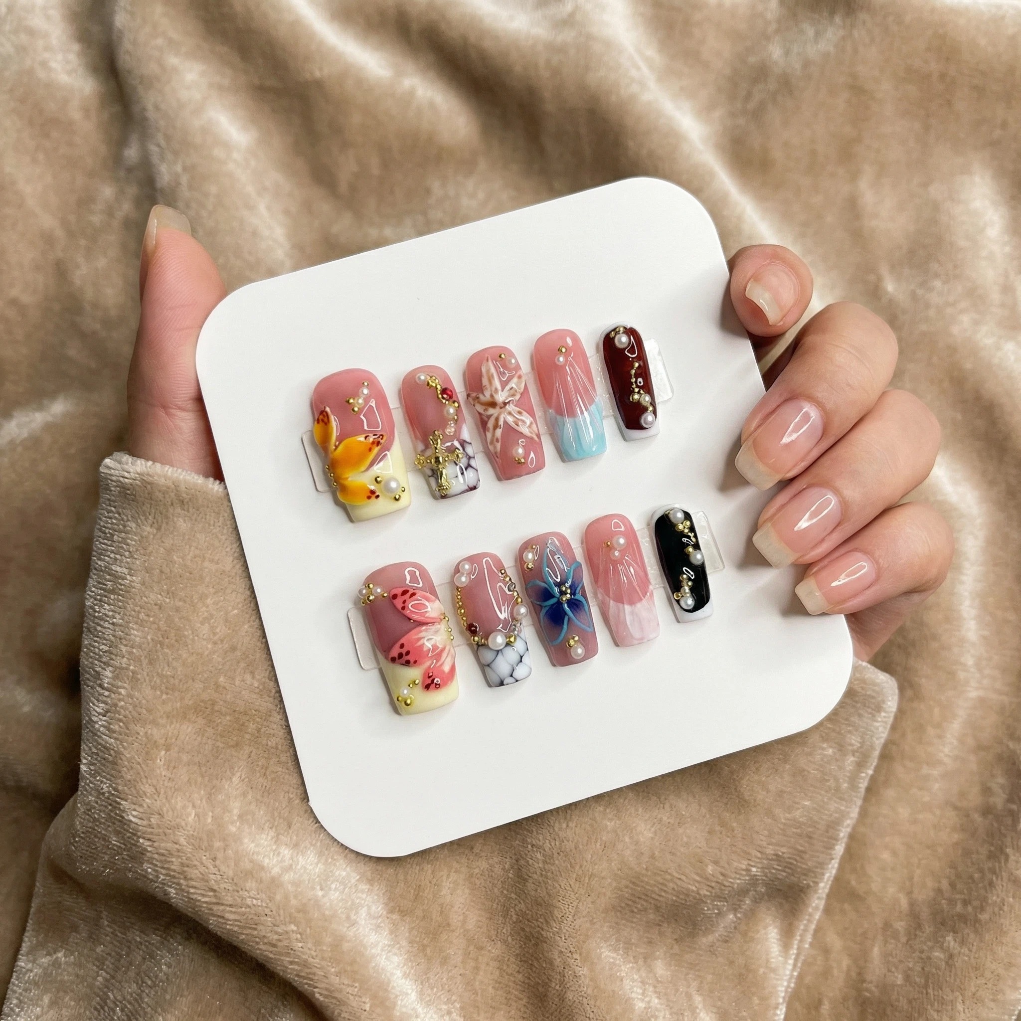 Nude pink floral butterfly press-on nails on display card, glossy art nail set
