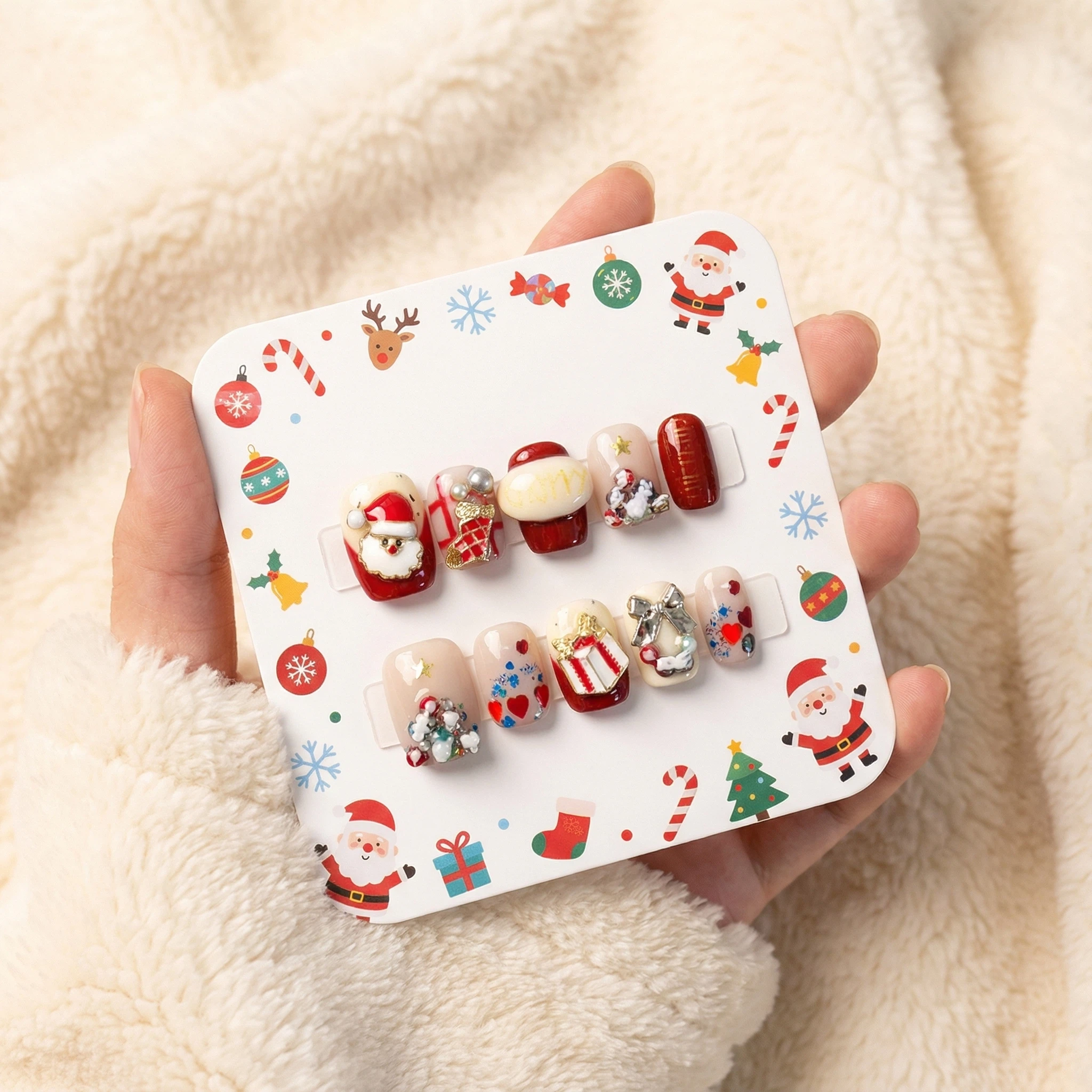 alt="Packaging card with red and nude Christmas Santa press on nails set decorated with gifts, hearts and crystals"