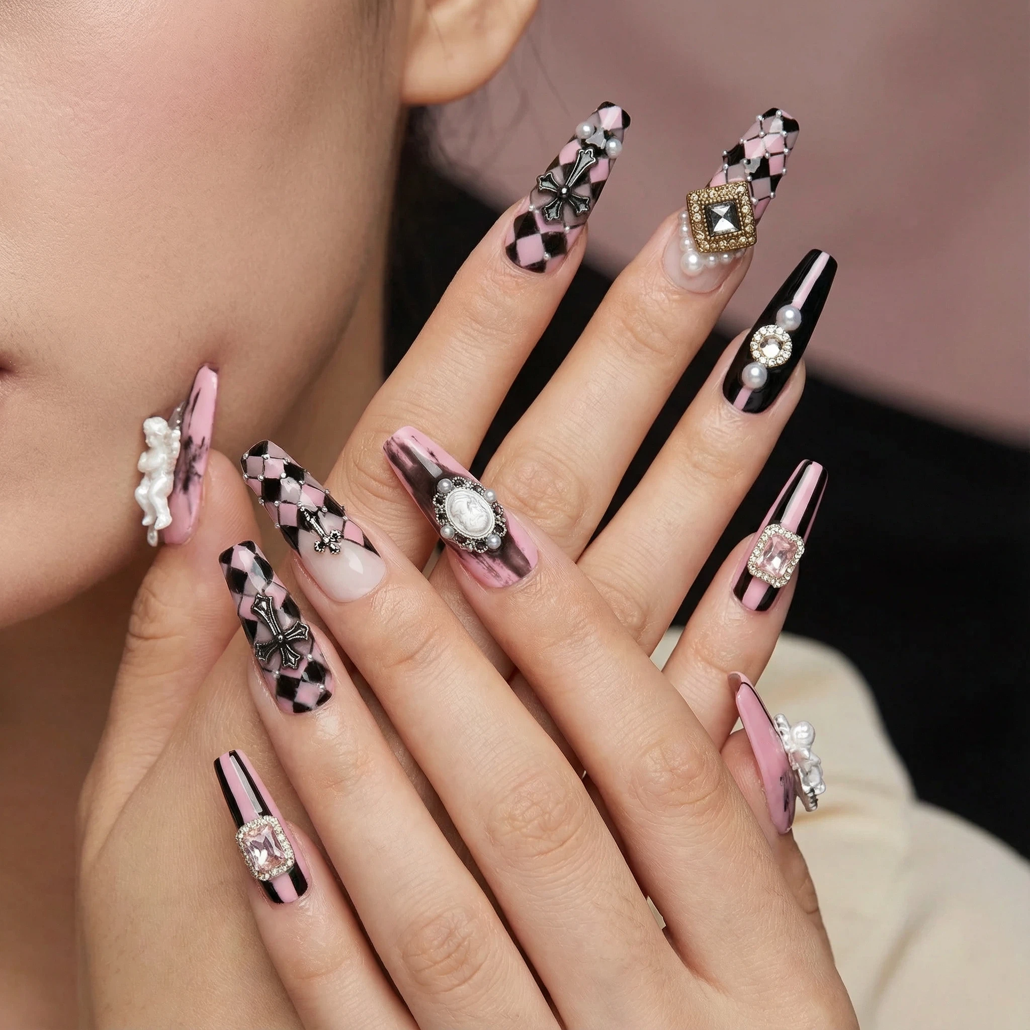 Model wearing pink and black press-on nails with rhinestones and statement charms, long glam style