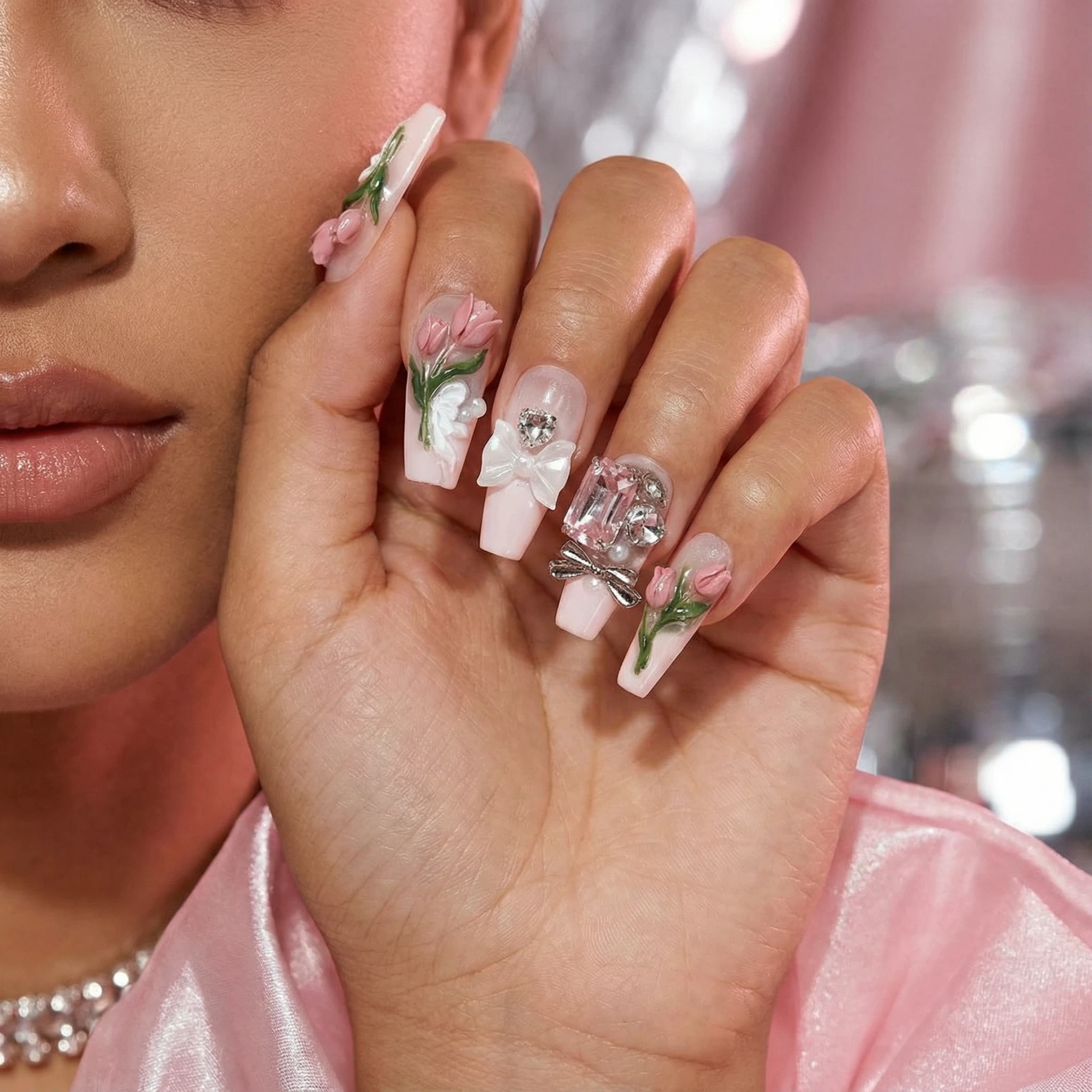 alt="Close up of pink tulip 3D flower press on nails on model's hand"