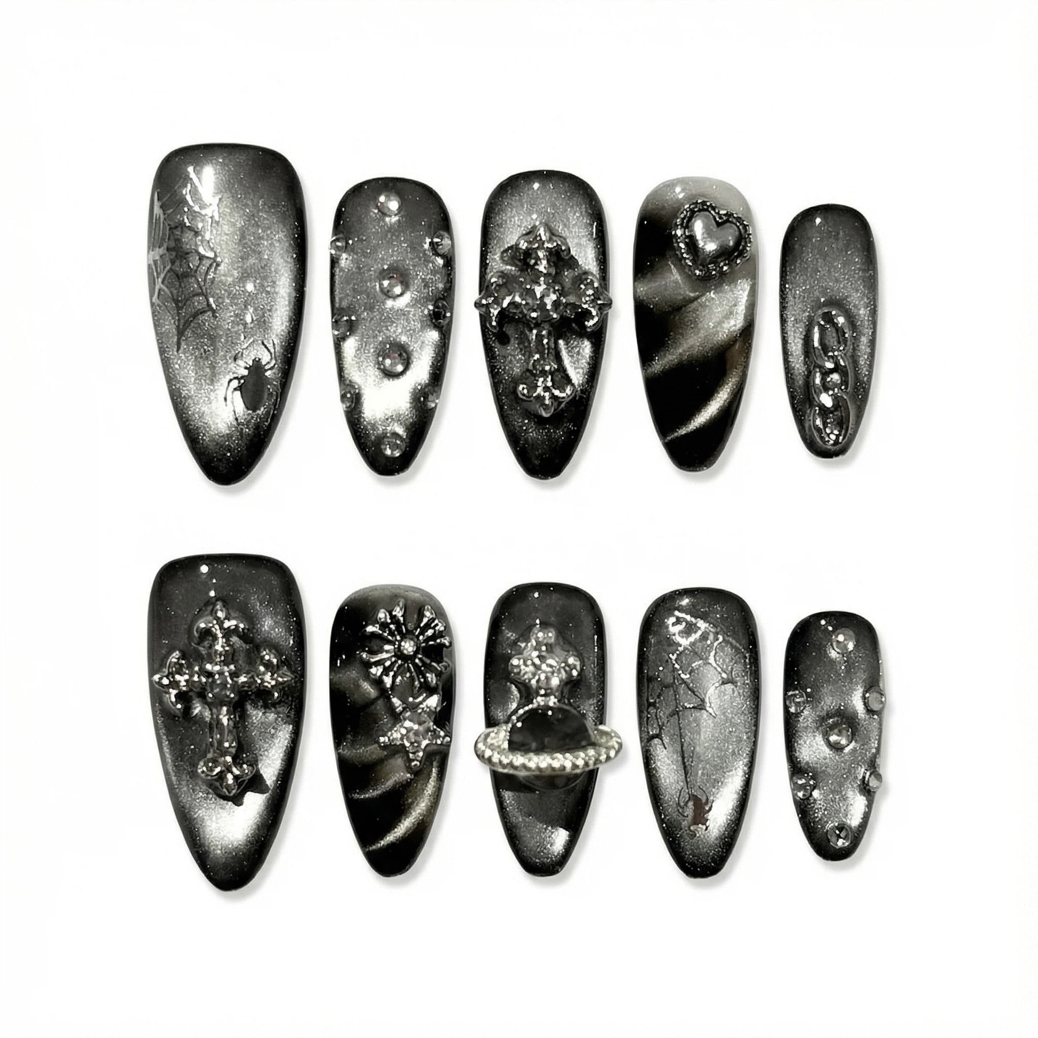 Flat lay of gunmetal gothic press-on nail set on white background showing multiple accent styles