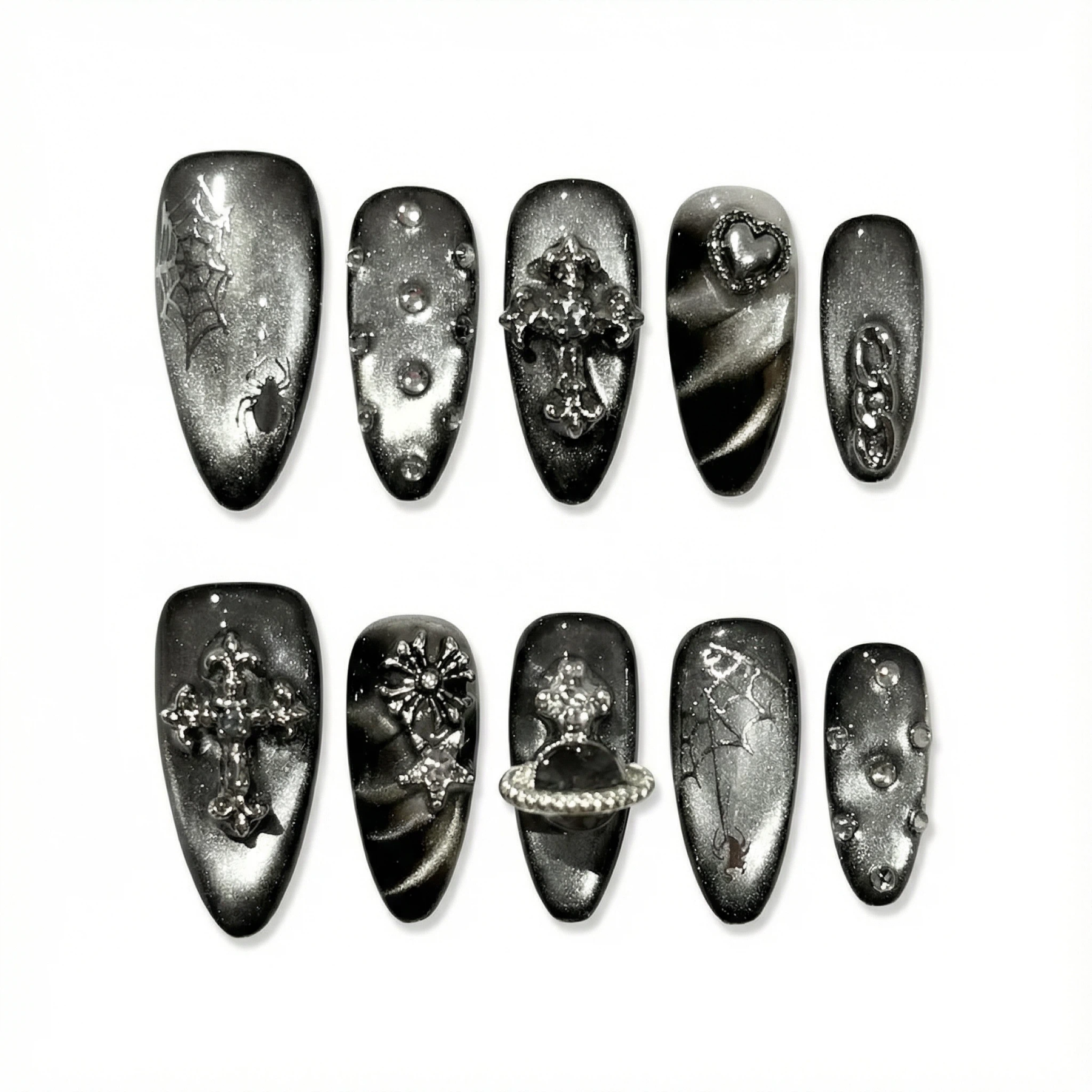 Flat lay of gunmetal gothic press-on nail set on white background showing multiple accent styles