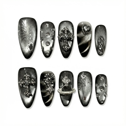 Flat lay of gunmetal gothic press-on nail set on white background showing multiple accent styles