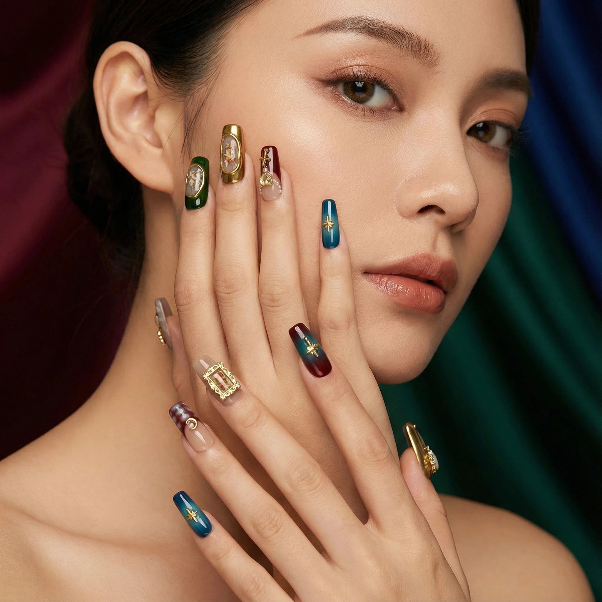 Luxury press-on nails close-up — emerald green and gold ornate design with statement accents for a salon look at home.