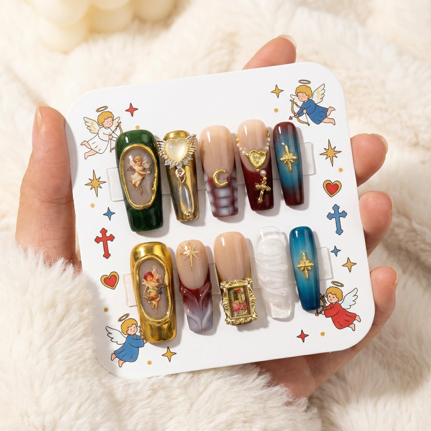 alt="Packaging card with vintage angel press on nails set in green, red and blue with gold details"