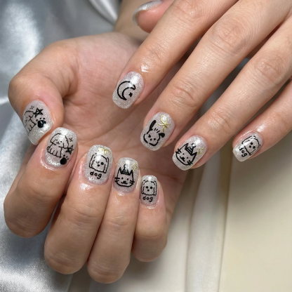 hands wearing silver glitter short press on nails with black pet doodle designs