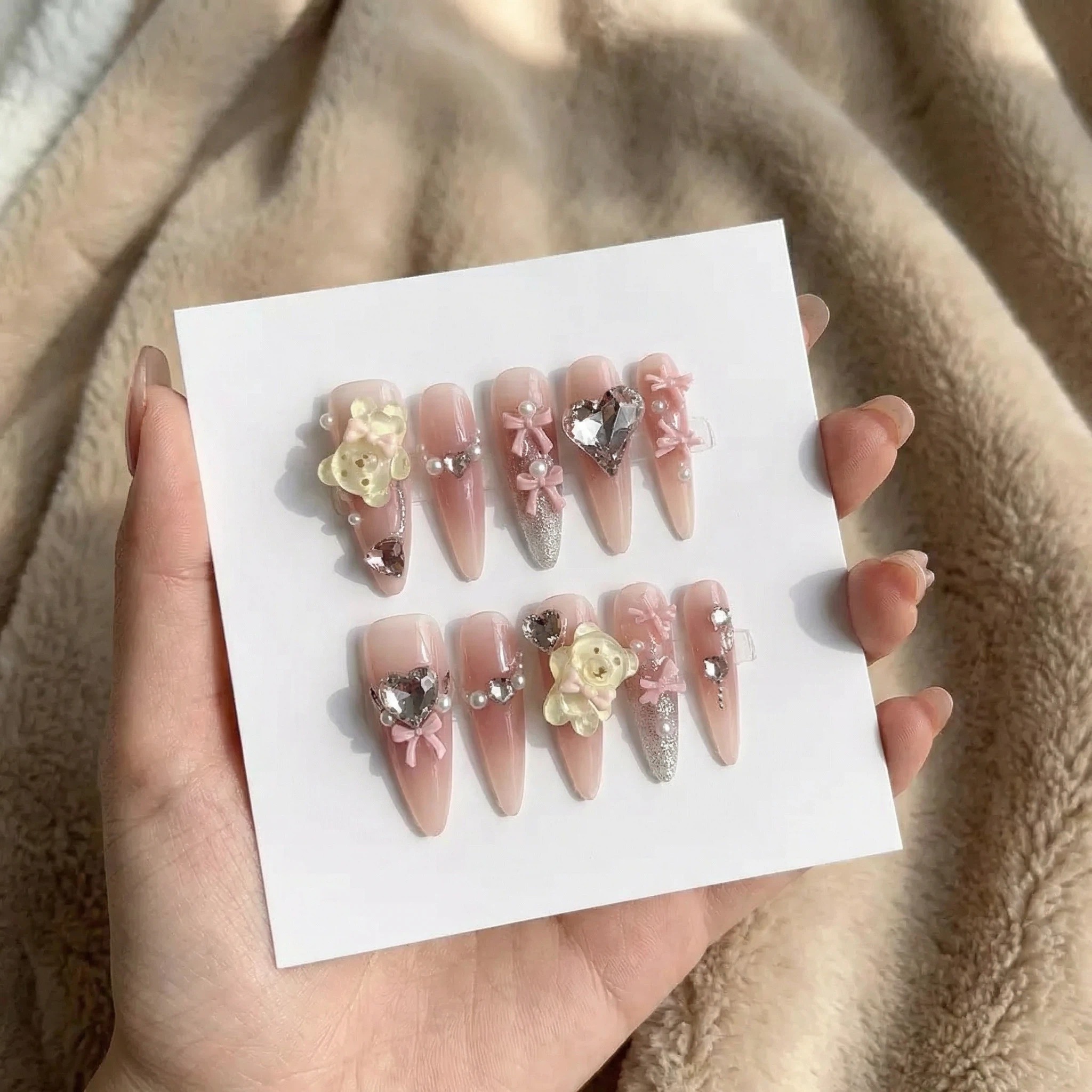 Blush pink 3D floral bow press on nails with rhinestones and pearl accents on display card